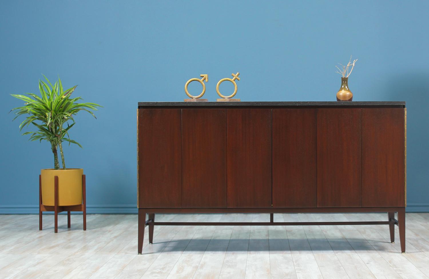 Mid Century modern credenza designed by Paul McCobb for the “Irwin Collection” at Calvin Group in the United States circa 1950’s. This stunning credenza sits on a beautiful mahogany base and features its original black marble top over the sturdy
