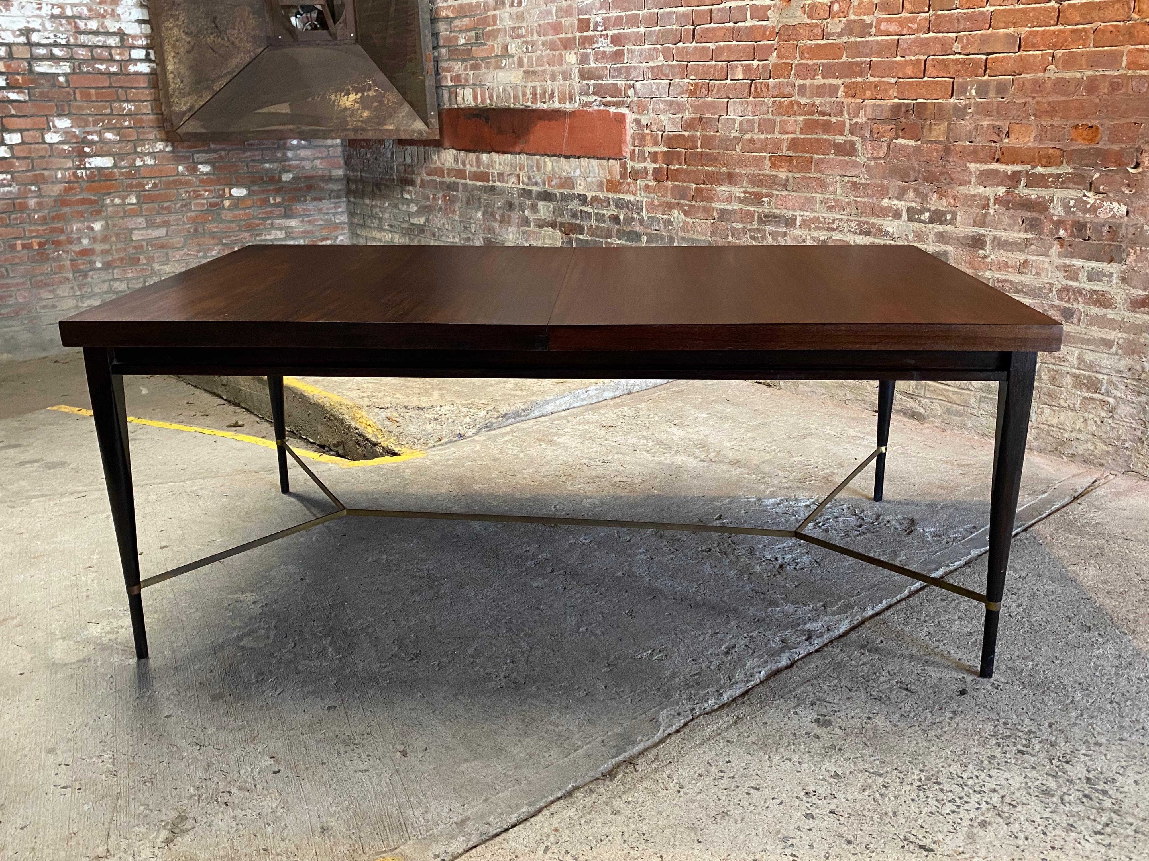 Mahogany and Brass dining table with leaves designed by Paul McCobb for Calvin. Signed with brass plate on the table top runners, Calvin, Grand Rapids, The Irwin Collection, Designed by Paul McCobb. Circa 1950-60. The table comes with two leaves;