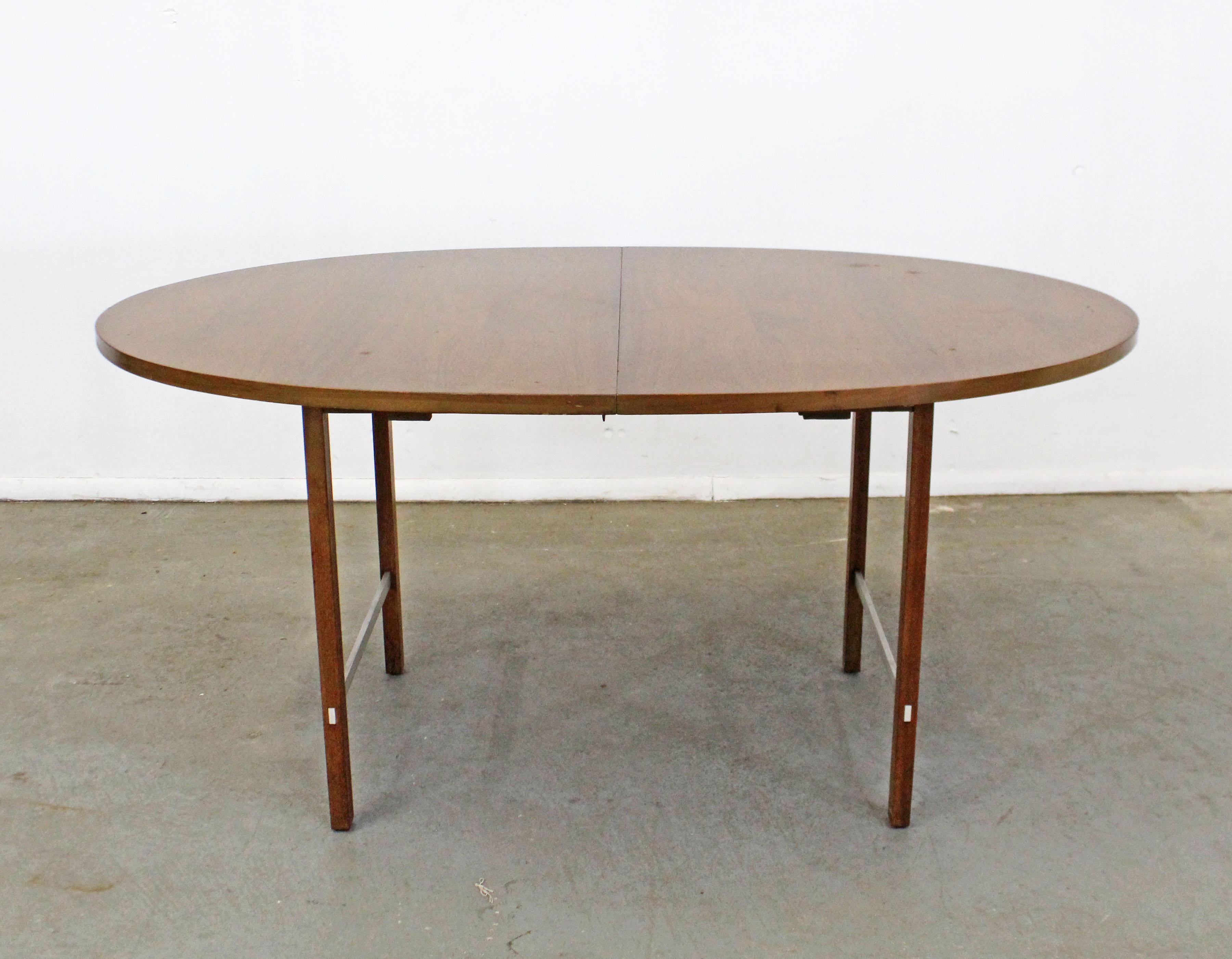 Nous vous proposons une table à manger vintage de style moderne du milieu du siècle, conçue par Paul McCobb pour la collection Irwin de Calvin. La table est fabriquée en noyer, avec un plateau ovale et des renforts en aluminium sur les pieds. Elle