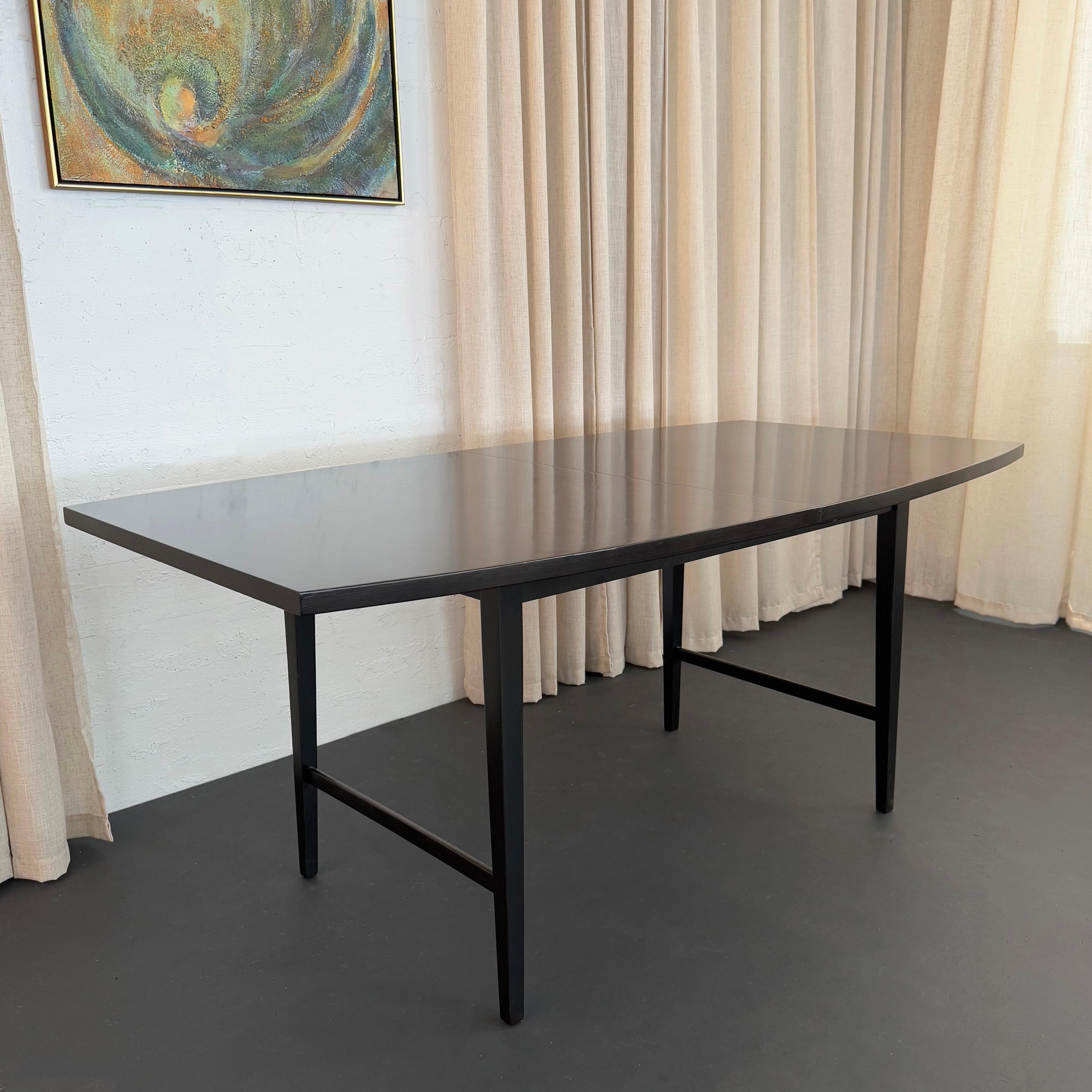 This Mid-Century Modern extension dining table was designed by the loved American designer Paul McCobb. The table is part of his Perimeter furniture line which was manufactured by Winchendon Furniture Company in Winchendon, MA. The model is number
