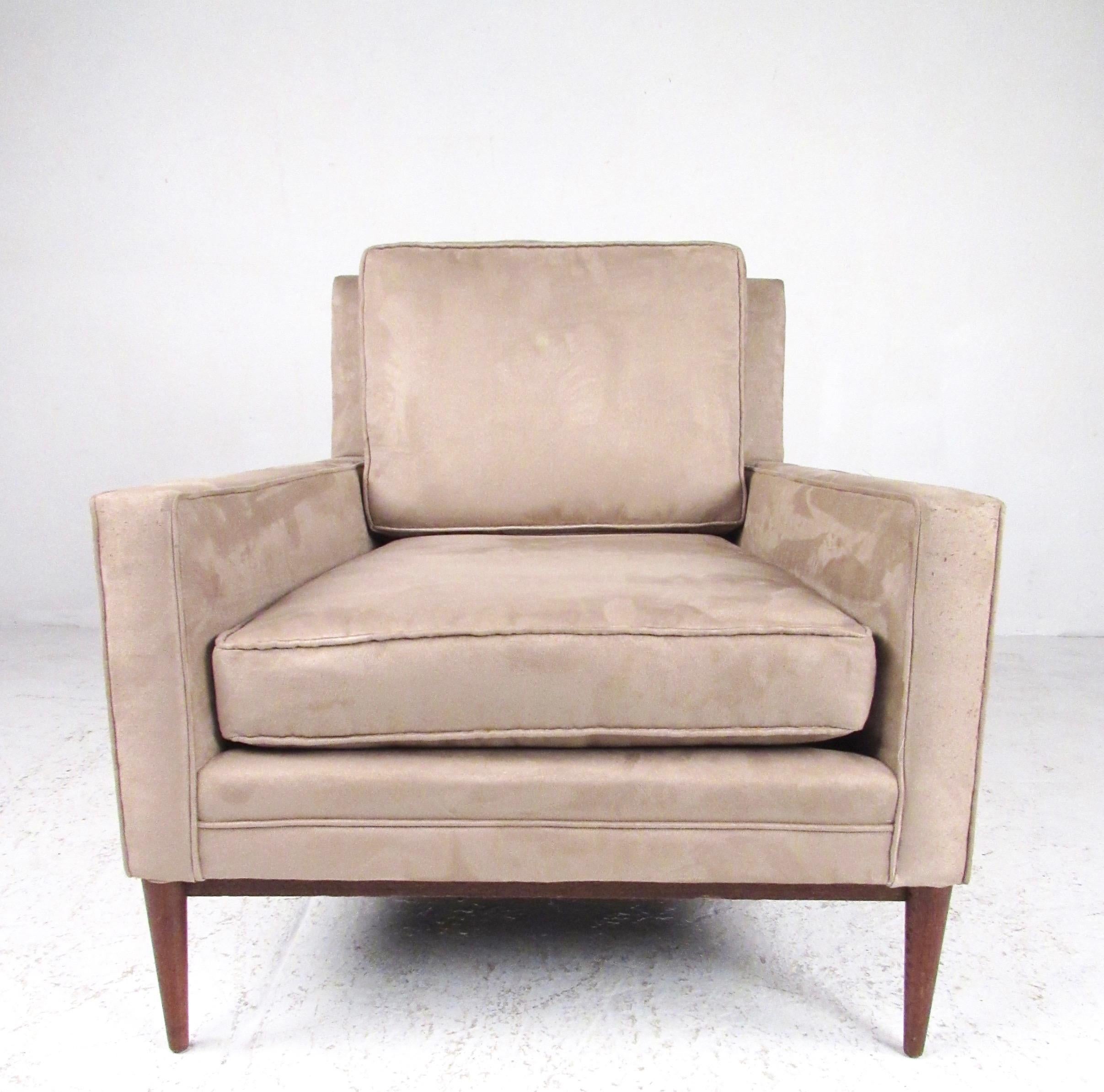 Dieser zeitlose Loungesessel von Paul McCobb vereint Komfort und Mid-Century Modern Style. Das robuste Untergestell aus Nussbaumholz mit konischen Beinen trägt eine schlichte, moderne Sitzfläche mit reichlich Platz für bequemes Sitzen in jedem