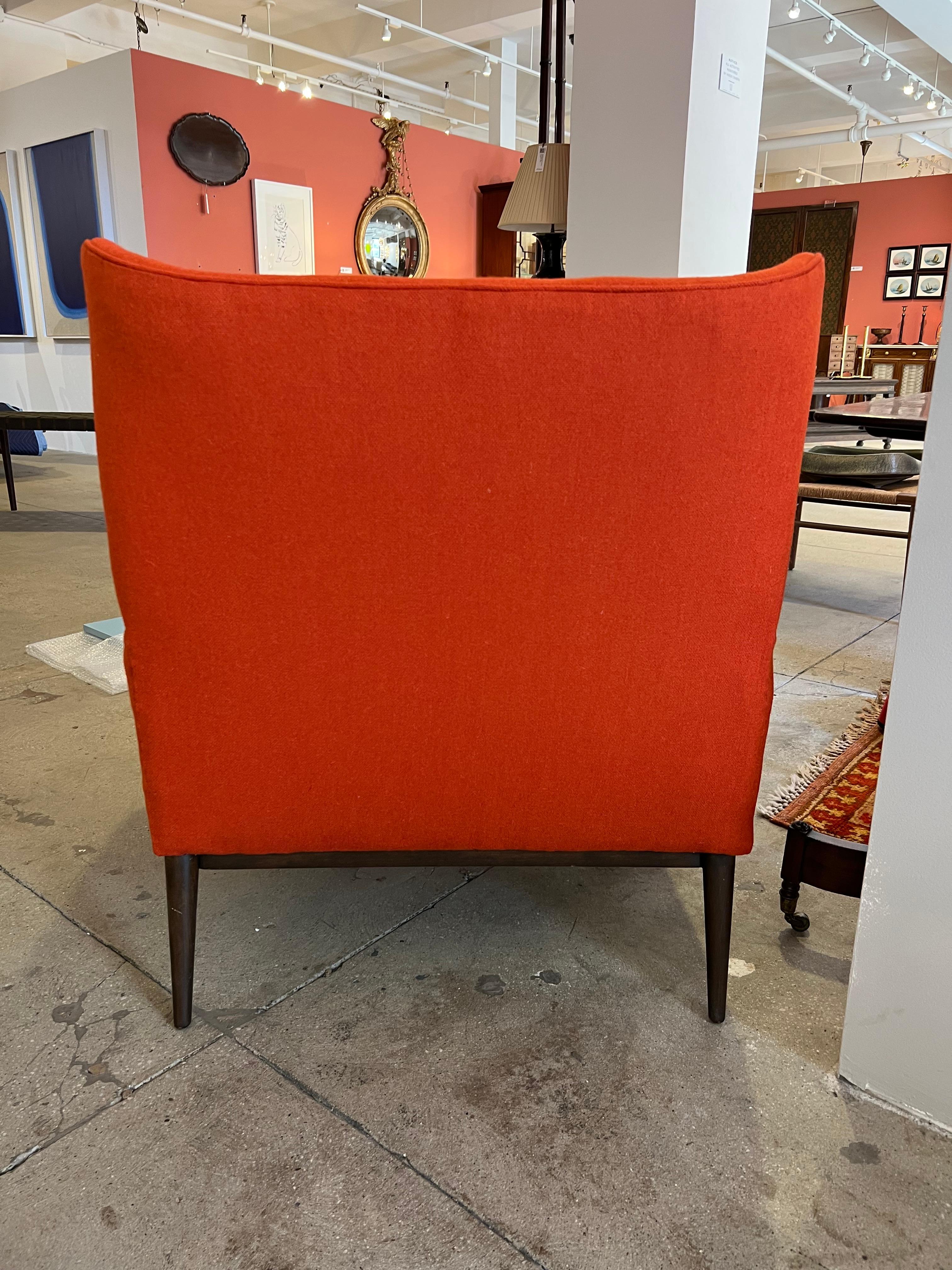Vintage Paul McCobb winged back lounge chair on tapering walnut legs, reupholstered in deep orange Maharam wool fabric.

 