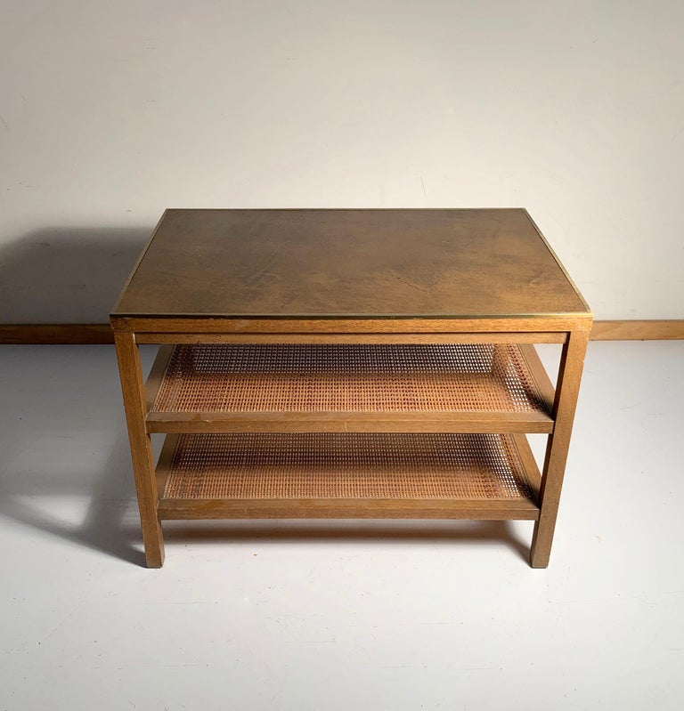 Paul McCobb magazine table. Caned shelves with leather top. Brass edging. High quality Paul McCobb.