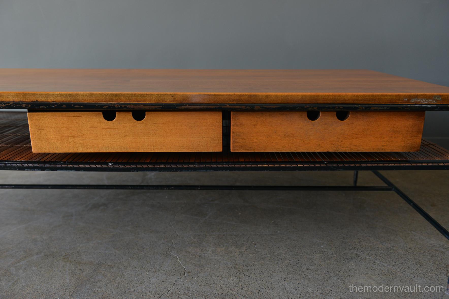 Paul McCobb maple and iron coffee table, circa 1955. Original vintage condition with wrought iron frame and lower woven bamboo shelf in excellent condition with no missing slats. Two slide out drawers are original along with the adjustable feet. In