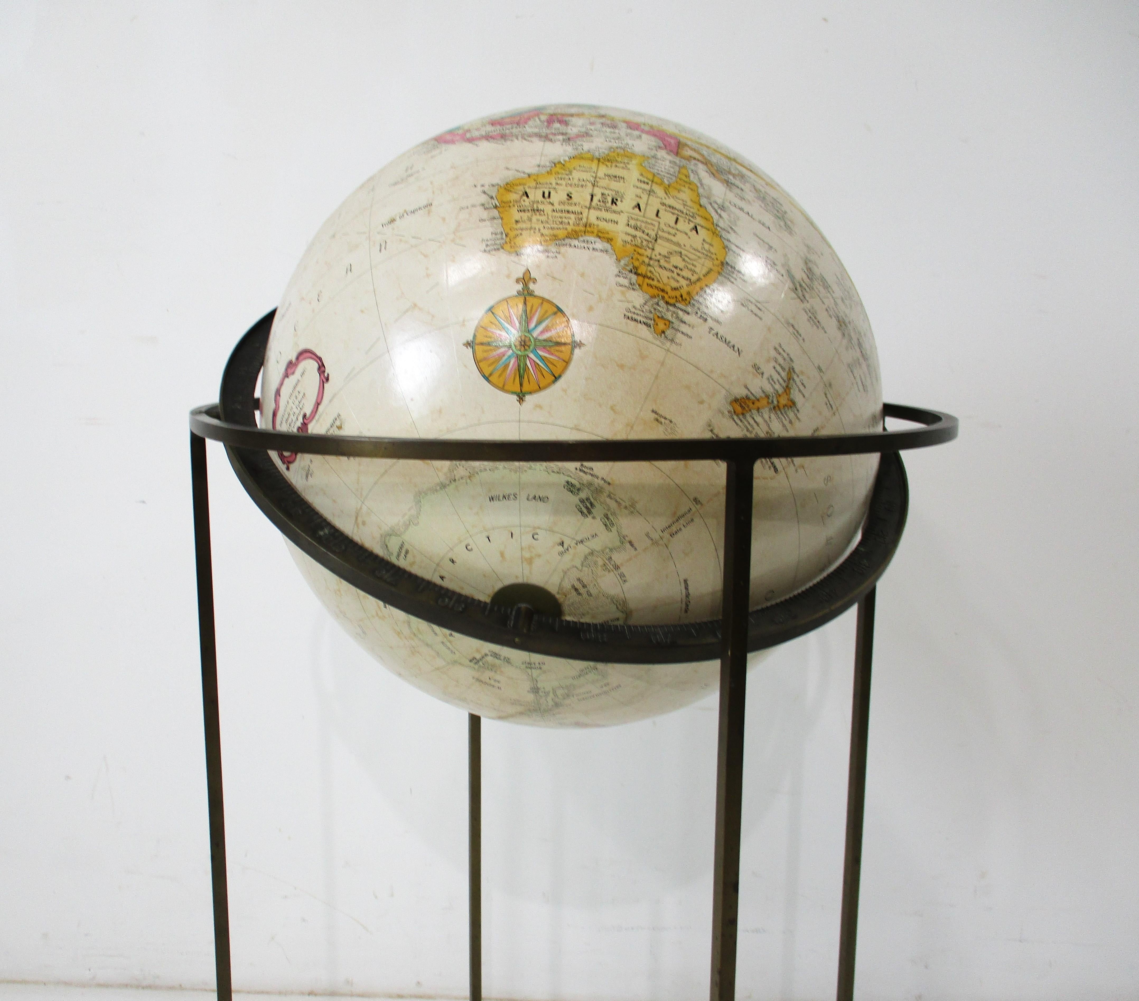 Globe terrestre du milieu du siècle avec cadre carré en laiton massif et globe tournant articulé avec les points de montage sur l'axe. Le globe est doté d'un anneau d'horizon céleste en métal, ce qui rend la pièce très utile et clairement imprimée.