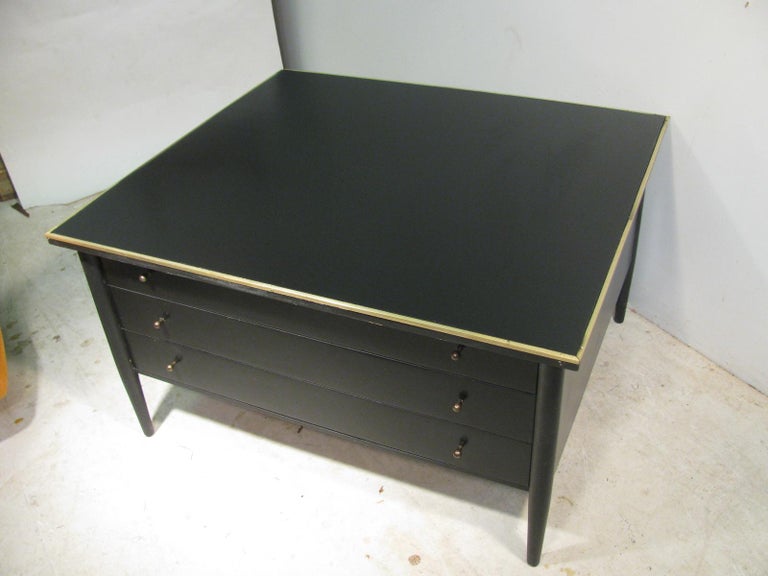 Paul McCobb Connoisseur collection for H. Sacks and Sons, Brookline mass. Three-drawer cocktail table or large end table in black lacquer. Top is framed in brass along with bronzed drawer pulls.