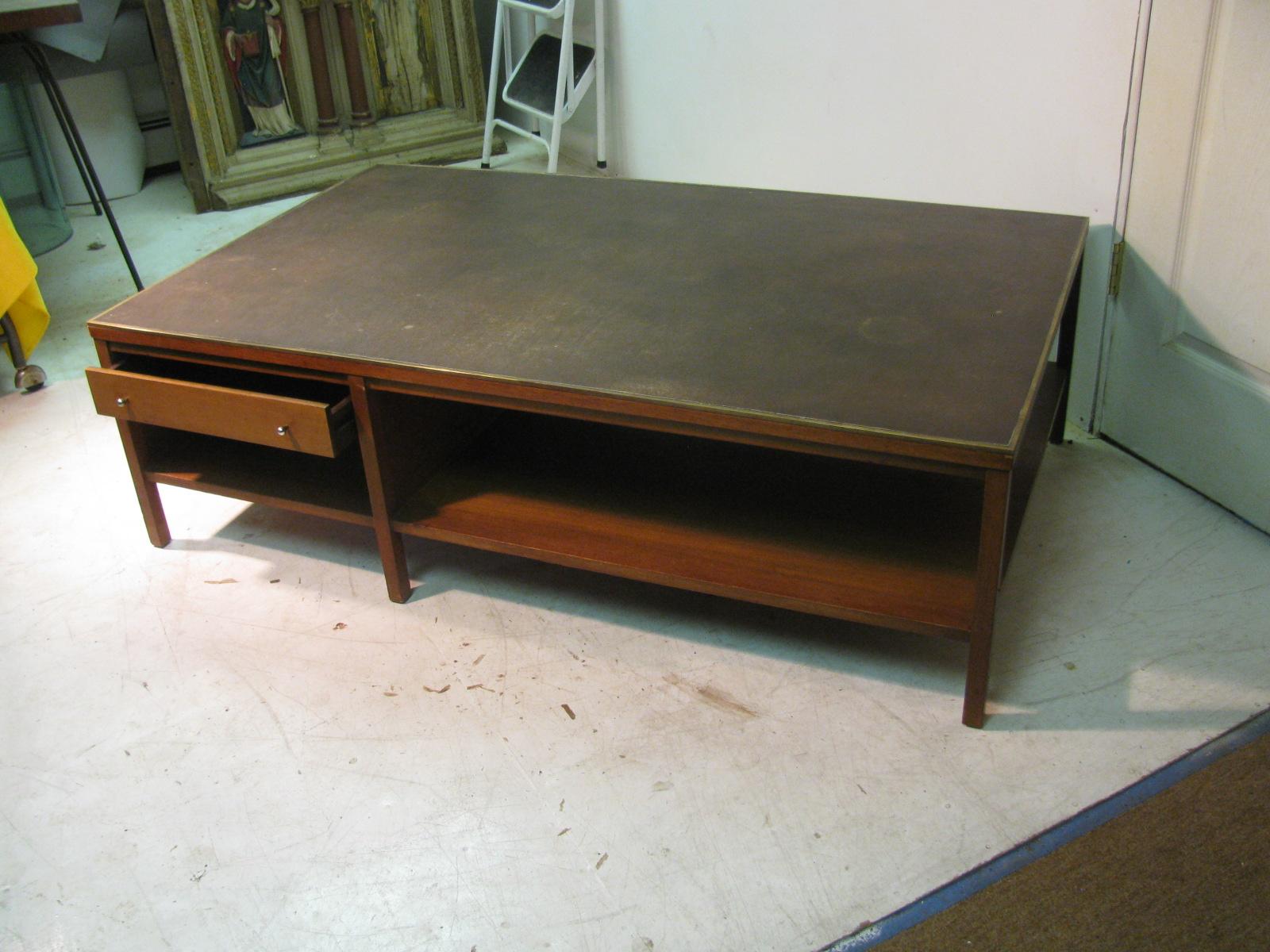 Fabulous leather cocktail table with a single drawer for storage. Created by Paul McCobb for Calvin using walnut with brass trim that surrounds the leather top.