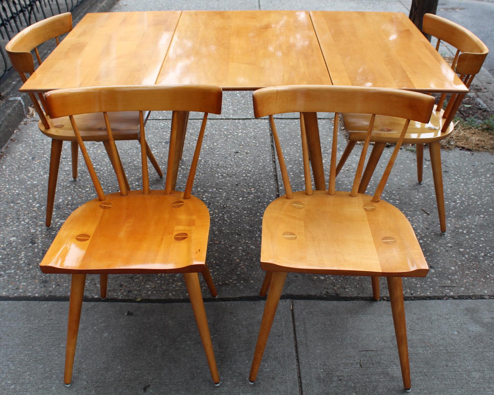 Paul McCobb Mid-Century Modern dining room set in maple wood, consisting of four chairs and a folding table. The set was manufactured in the United States in the 1950s and is in very good vintage condition.