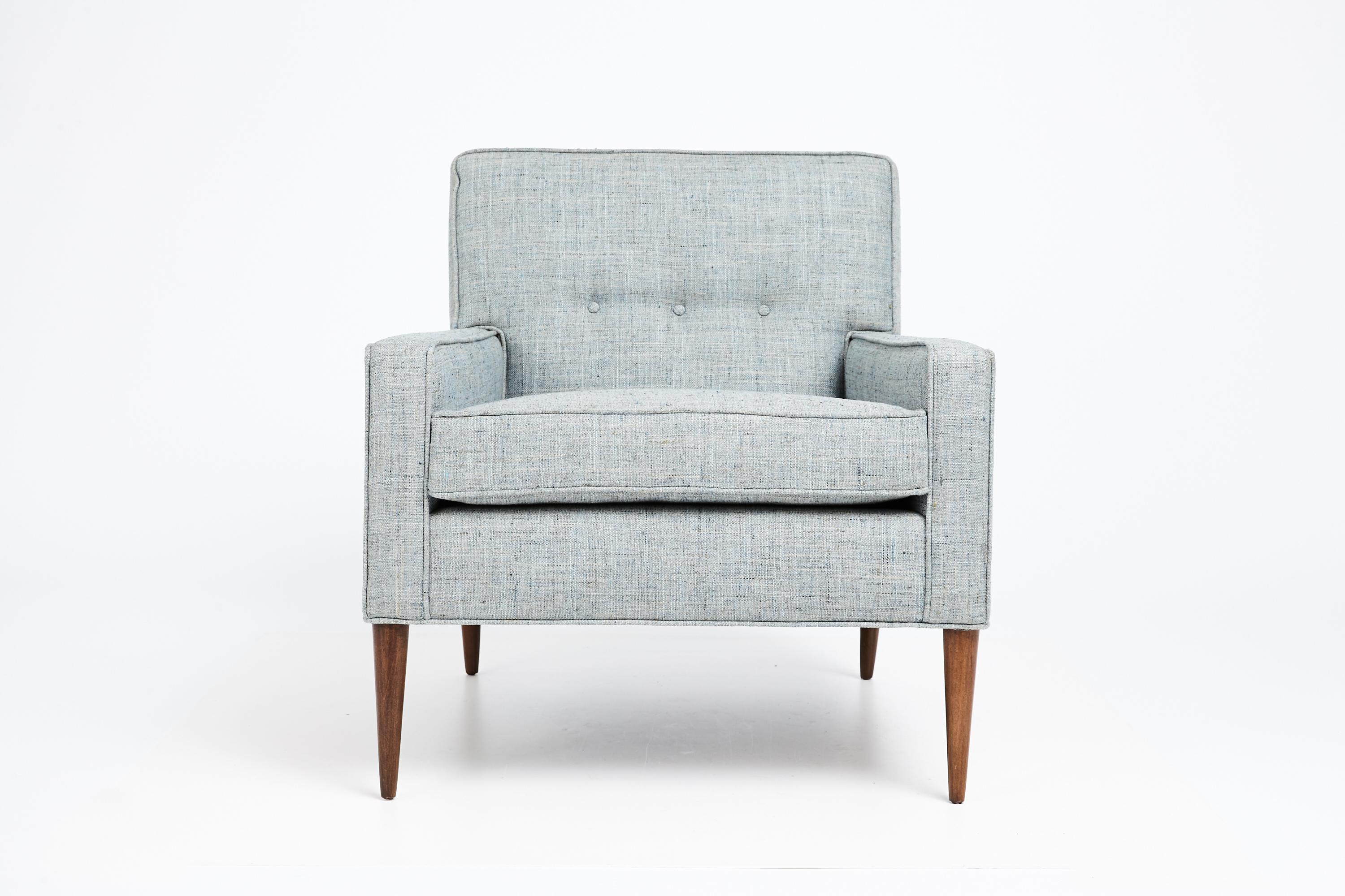 Elegant club chair designed by Paul McCobb in the mid 1950s. Classic McCobb design featuring clean lines, slender tapered legs and tufted detail on seat back. The chair has been fully restored from top to bottom. Newly reupholstered in a woven blue,