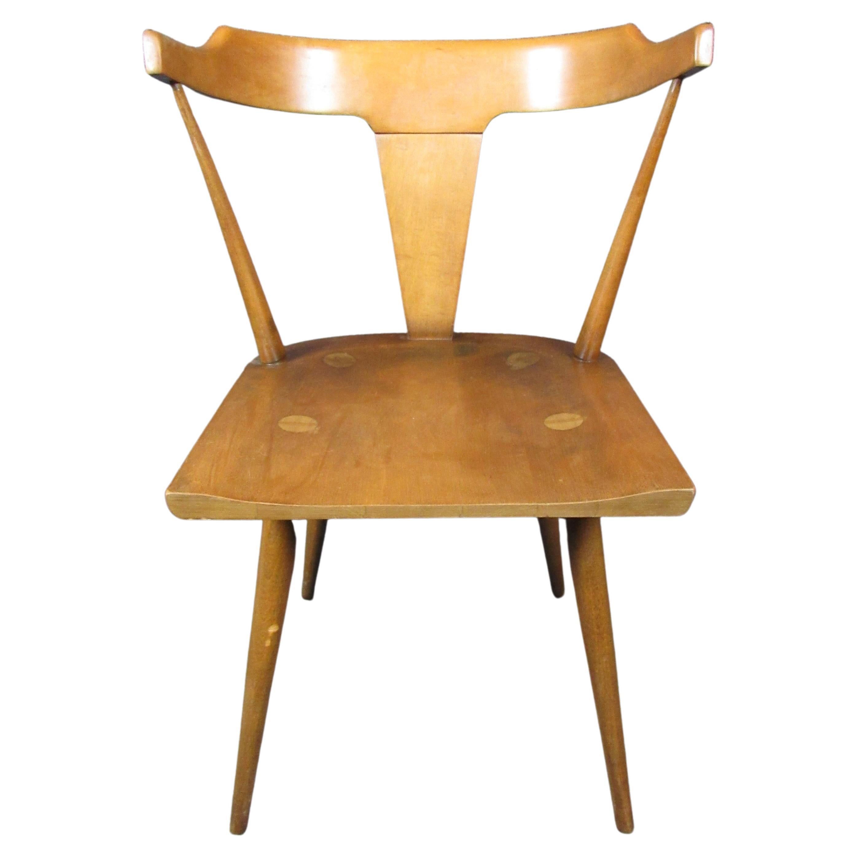 Bring home authentic Mid-Century Modern design with this fantastic chair by Paul McCobb for the Planner Group. Featuring the golden maple wood grain, turned peglegs, and Windsor-inspired spindles that made McCobb famous, this wonderful seat sports a