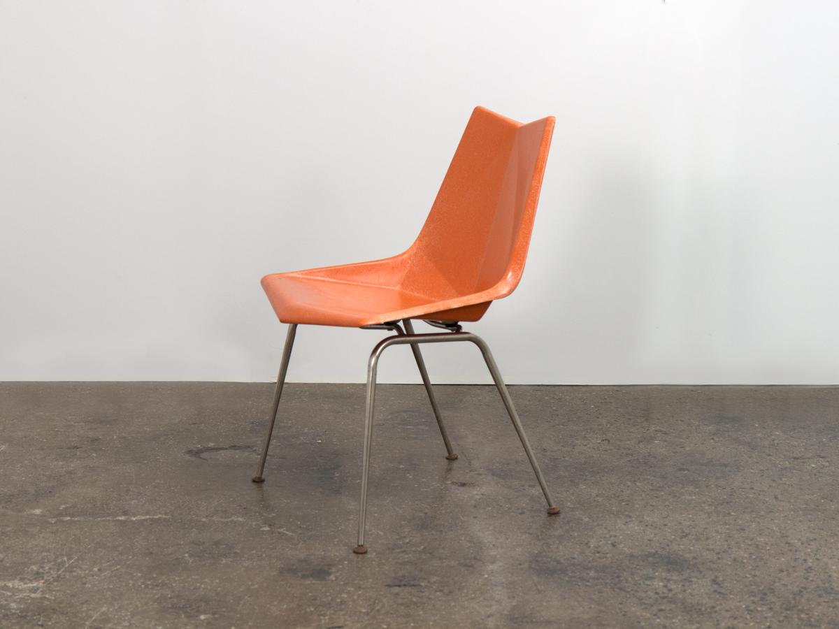 Sedia a guscio Origami vintage di colore arancione su base metallica, disegnata da Paul McCobb per St. John Seating Corp. Una rivisitazione della classica forma a conchiglia, questa sedia sfaccettata presenta un filo conduttore distinto su tutta la