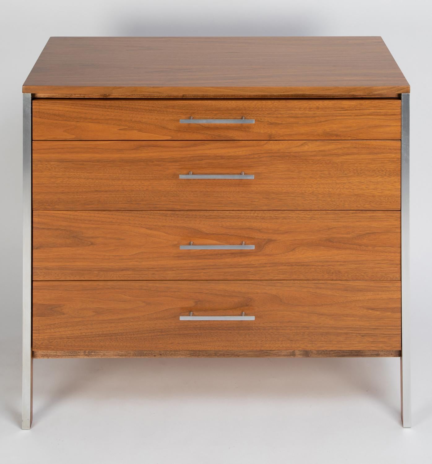 Pair of 4 drawer chests in walnut with aluminum pulls and trim by Paul McCobb for Calvin Furniture, American 1960's.  These clean line chests would be used as bedside tables.  They are chic.
