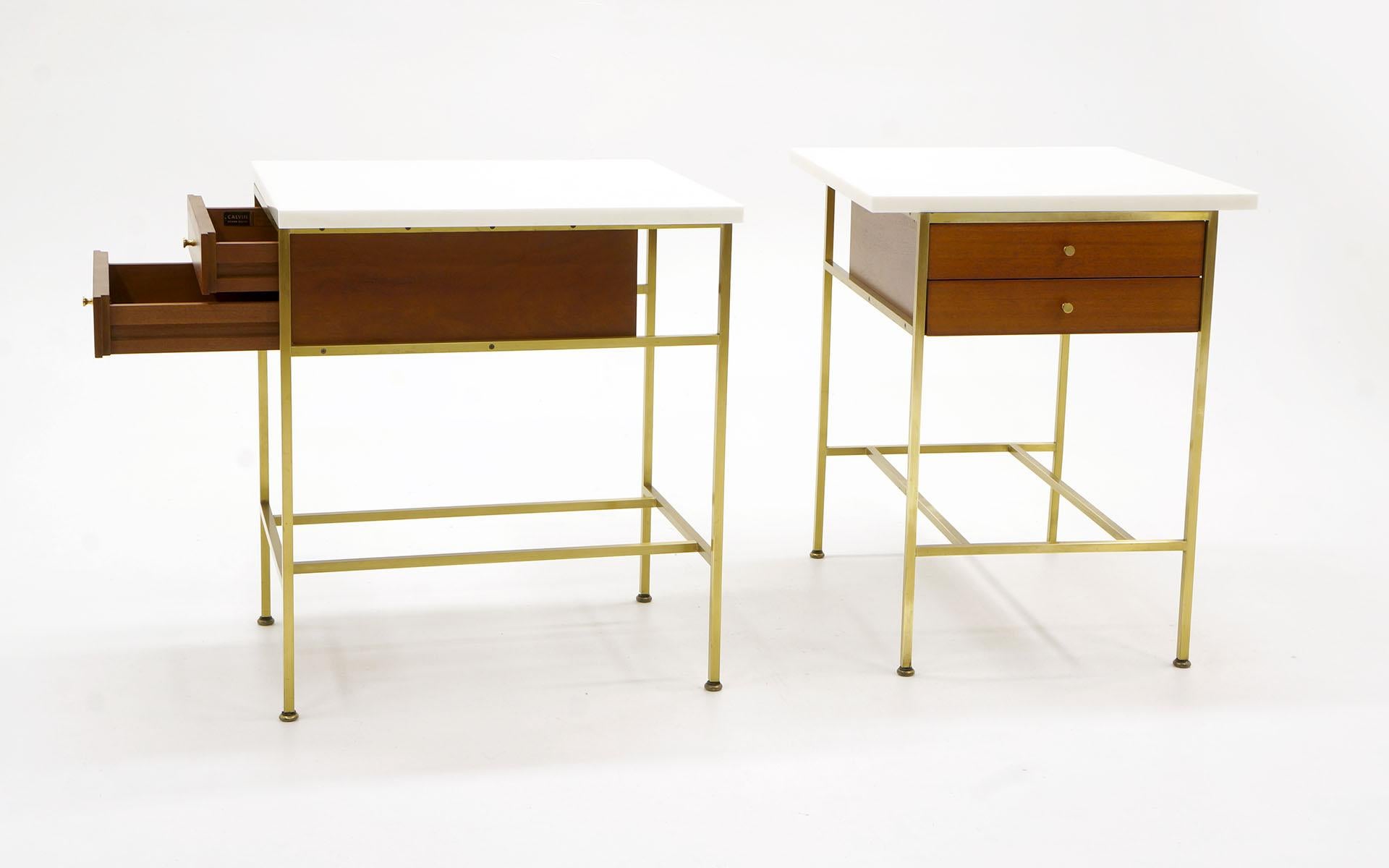 Paul McCobb pair of night stands / side tables. One of the most desirable forms. Solid brass tube frames, mahogany case with milk glass tops and original brass pulls. Signed with the Paul McCobb Irwin Collection for Calvin Furniture label. These