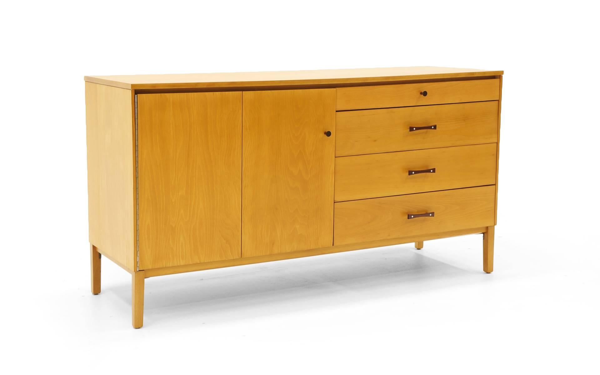 Dresser or storage cabinet designed by Paul McCobb. Beech case with Brazilian rosewood pulls. Expertly restored and refinished. Note: The bi-fold door reveals storage with an adjustable shelf. The shelf is not pictured.