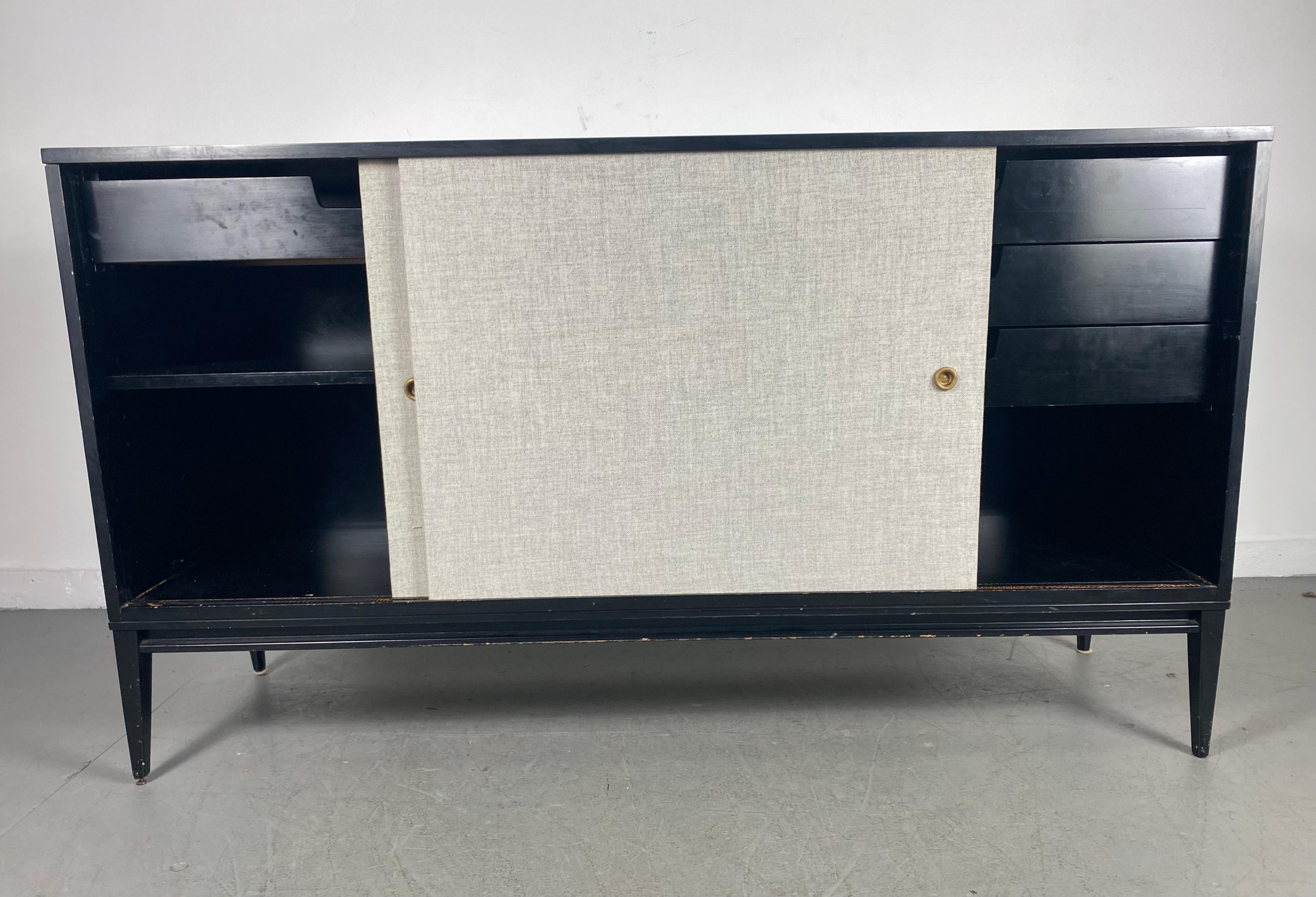 Classic server, credenza designed by Paul McCobb / Planner Group, retains original black lacquer finish, minor blemishes, two sliding doors recently recovered in grey linen fabric. Nice blonde birch interior adds to this classic design, hand
