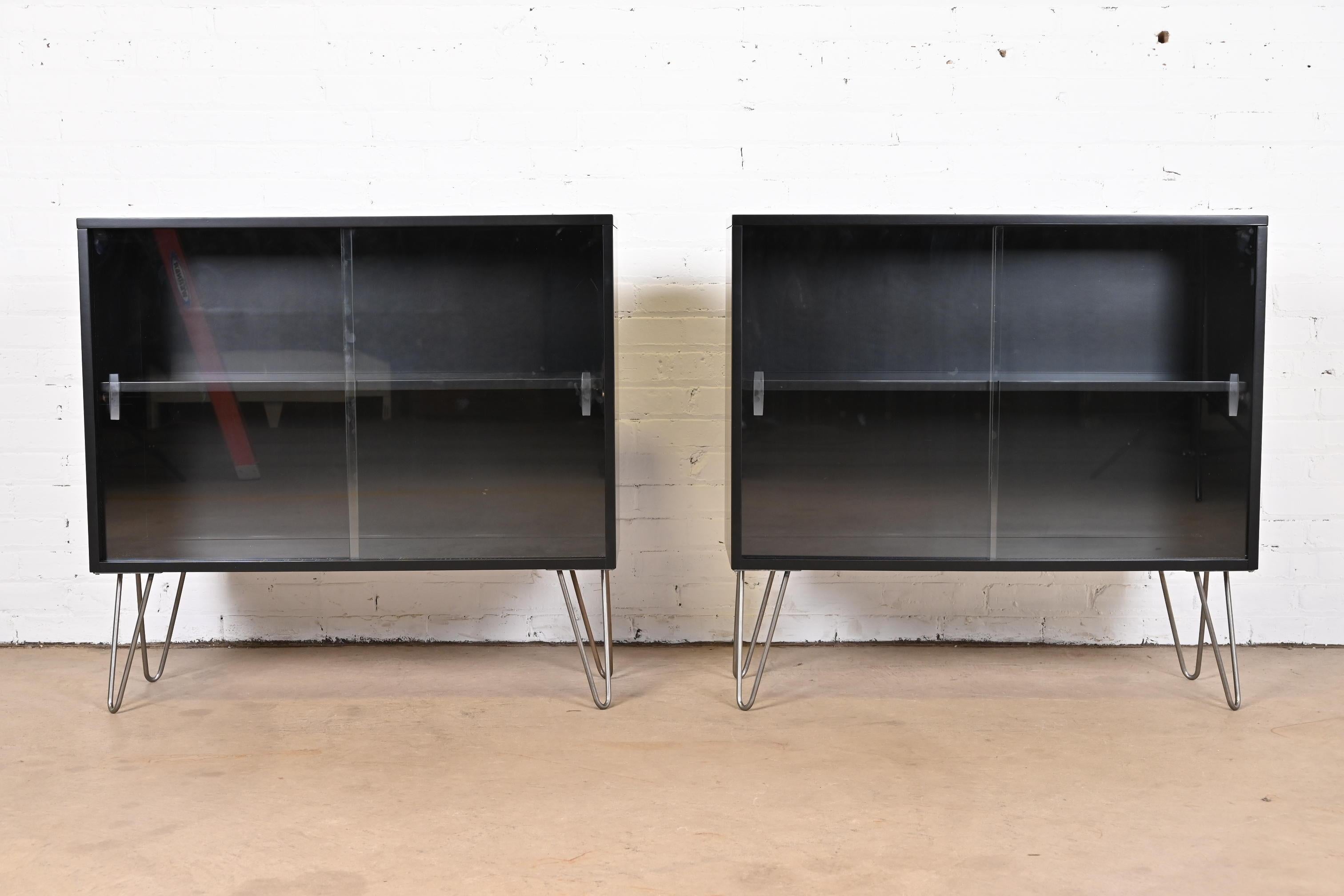 A sleek and stylish pair of Mid-Century Modern glass front bookcases on hairpin legs

By Paul McCobb for Winchendon Furniture, 