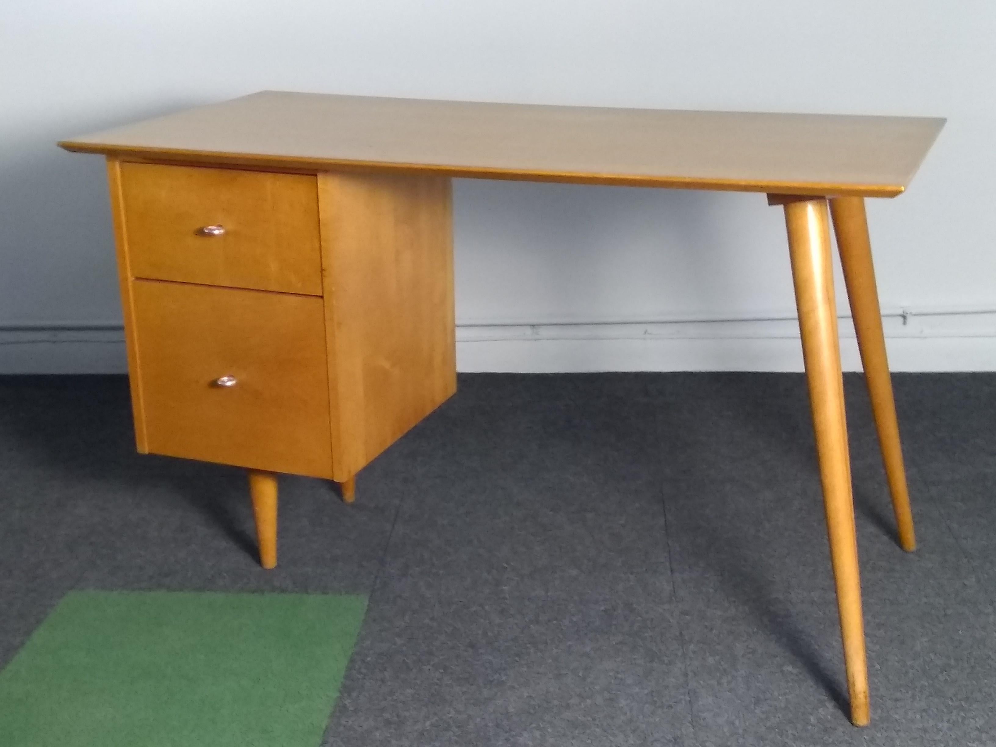 Simple, clean lines on this 1950's Paul McCobb, American maple writing desk. Rare ring pulls, stunning tapered legs mounted at the perfect angle. In wonderful original condition. 
Drawer side is branded Paul McCobb 