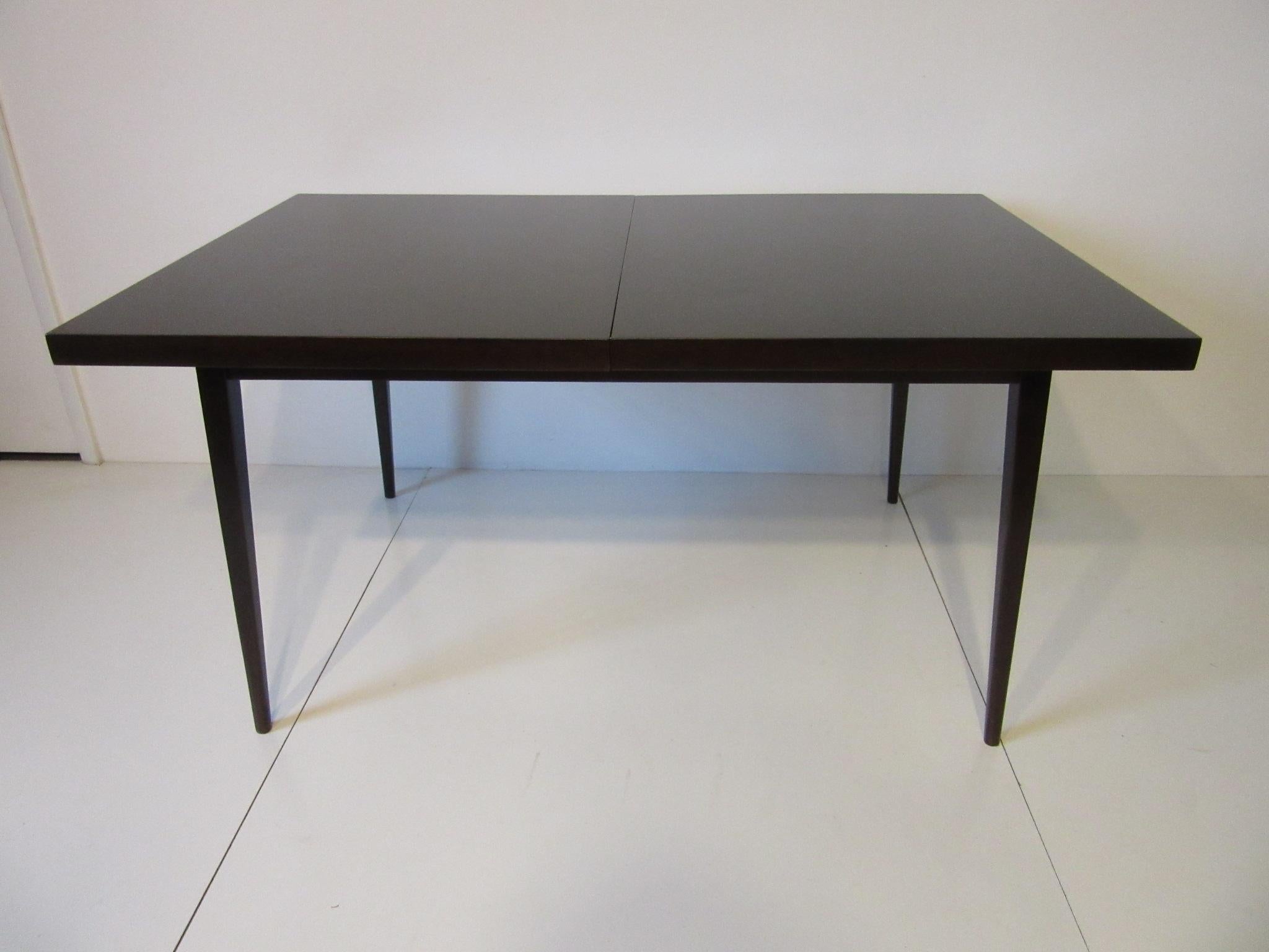 A dark ebony finished dining table with two 12
