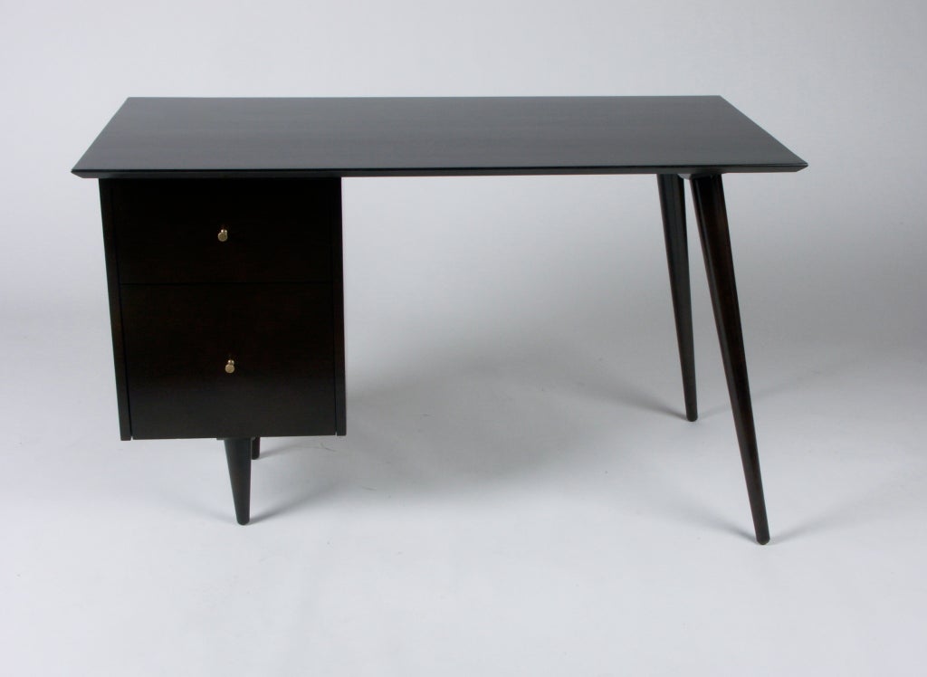 Paul McCobb Planner Group desk in dark espresso stain, with bank on drawers on left side and two tapered angular dowel legs on the right, tapered brass pulls. To be refinished in dark espresso finish, the desk shown is sold, so custom color options