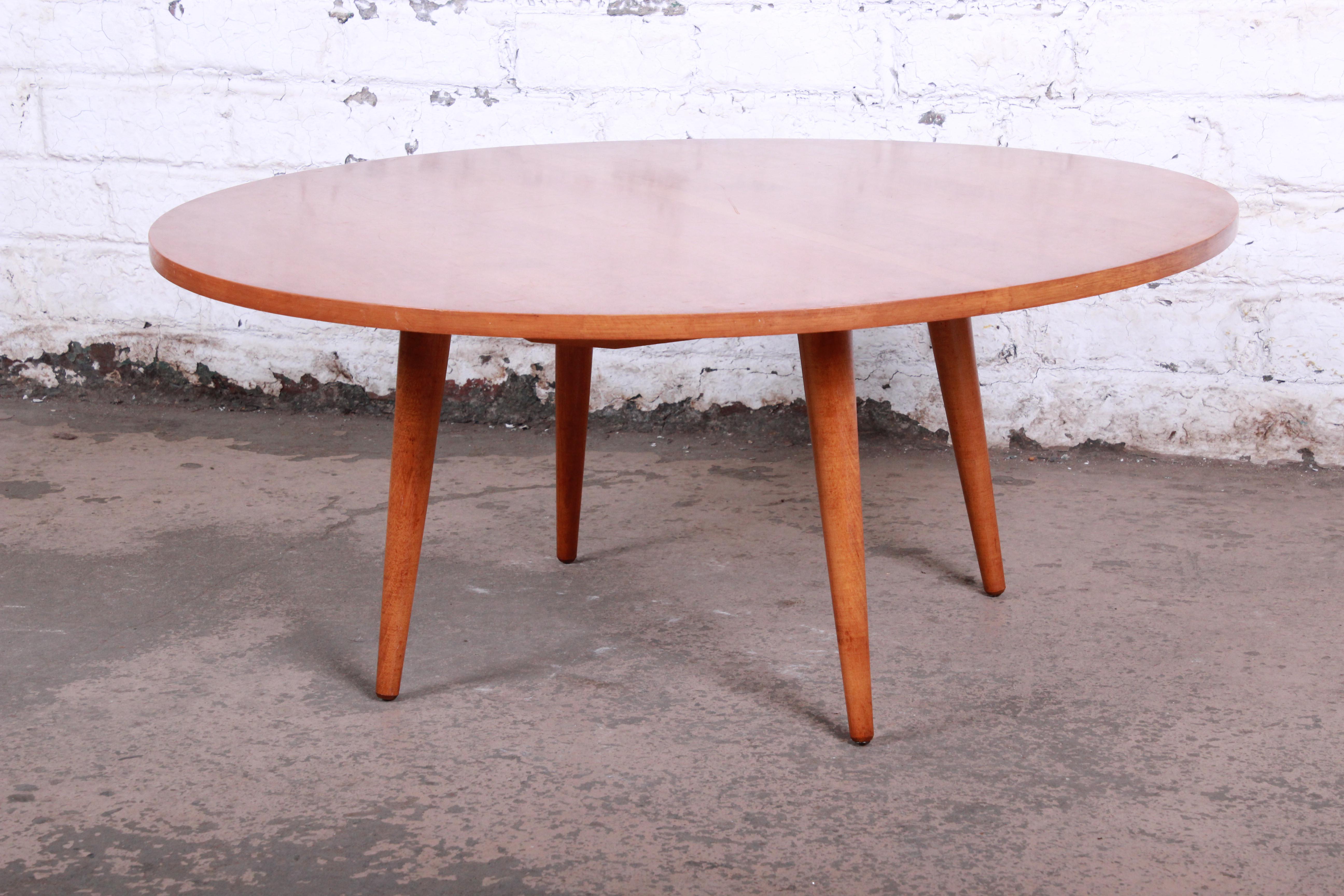 An exceptional Mid-Century Modern round coffee table designed by Paul McCobb for his Planner Group line for Winchendon Furniture. The table features gorgeous wood grain with solid maple construction and McCobb's iconic Minimalist design, including