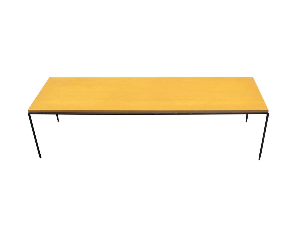 A Planner Group coffee table or bench designed by the American designer Paul McCobb (1917-1969). The table has a light wooden top supported by round iron metal legs. The underside of the table is marked with a Planner Group sticker to the underside.