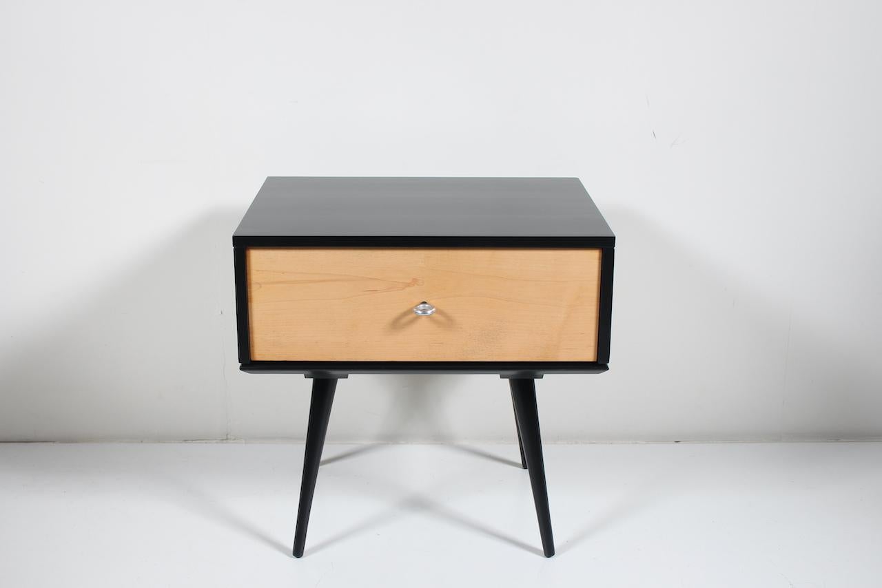 Paul McCobb Planner Group for Winchendon Single Drawer Maple Nightstand. Cabinet. End Table. Featuring a Black lacquered surround with solid Maple Drawer, original Aluminum donut ring pull. Model 1500. a top a 1540 Black enameled splayed legged