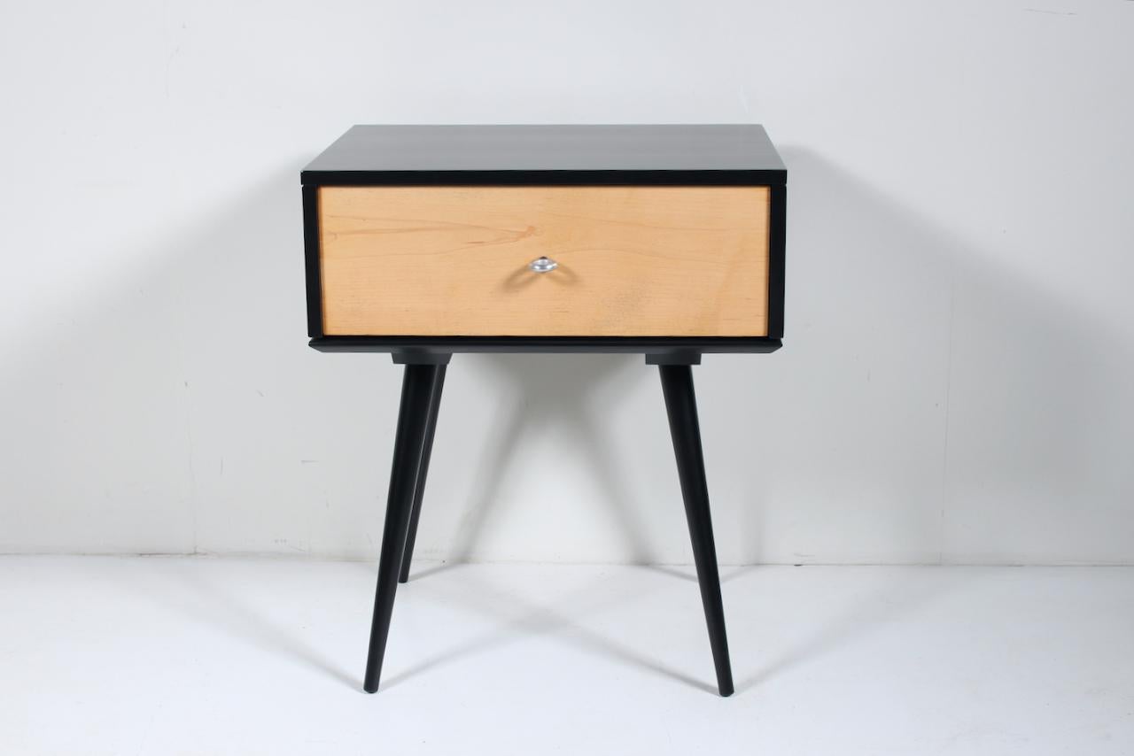 Paul McCobb Planner Group for Winchendon Single Drawer Maple Nightstand. Cabinet. End Table. Featuring a Black lacquered surround with solid Maple Drawer, original Aluminum donut ring pull. Model 1500. A top a 1540 Black enameled splayed threaded