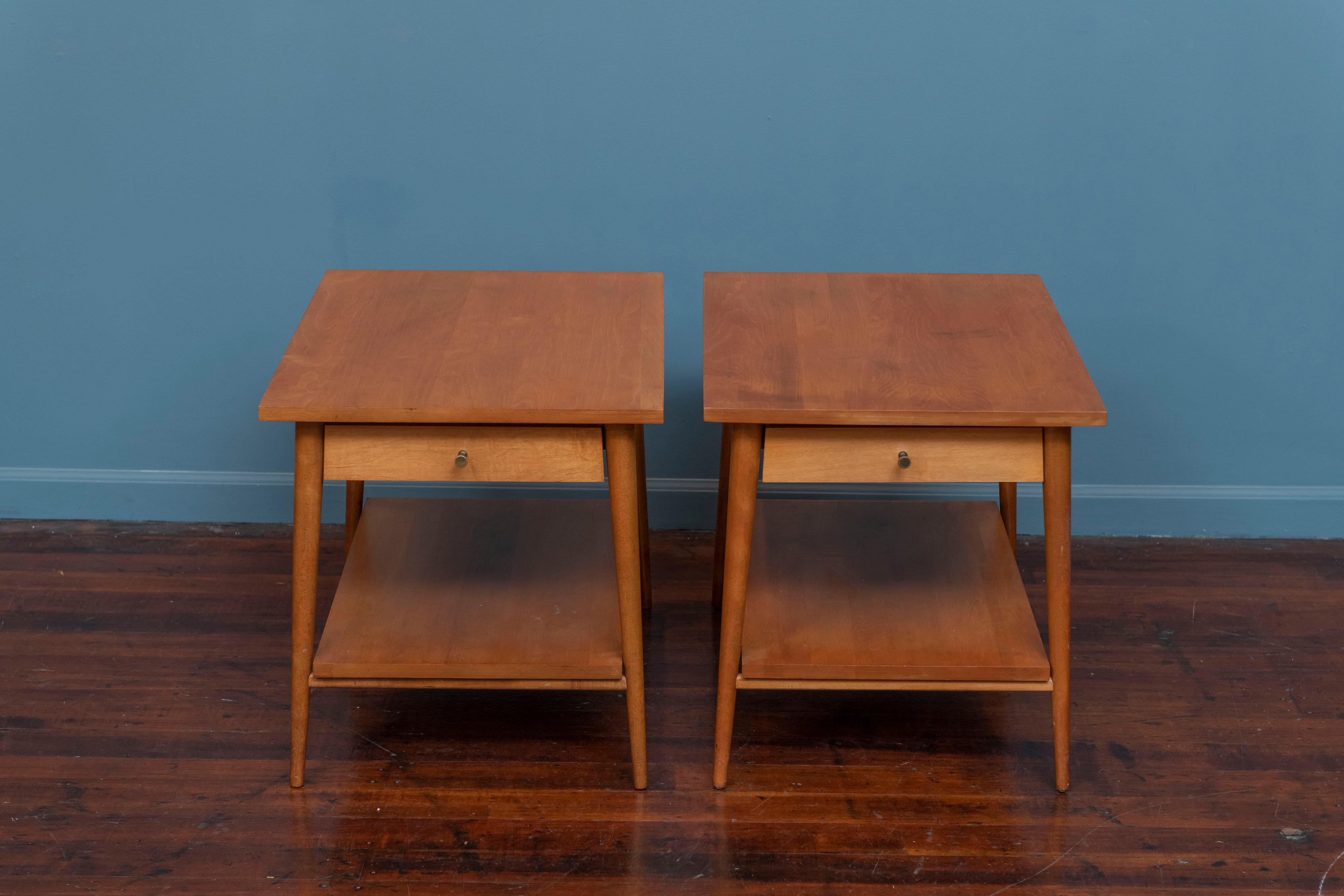 Pair of Paul McCobb design Planner Group side tables for Winchendon Furniture. Original matched pair in solid maple with brass cone shape pulls, labeled and in very good original condition. 
One table has a faint shadow of a stain but still