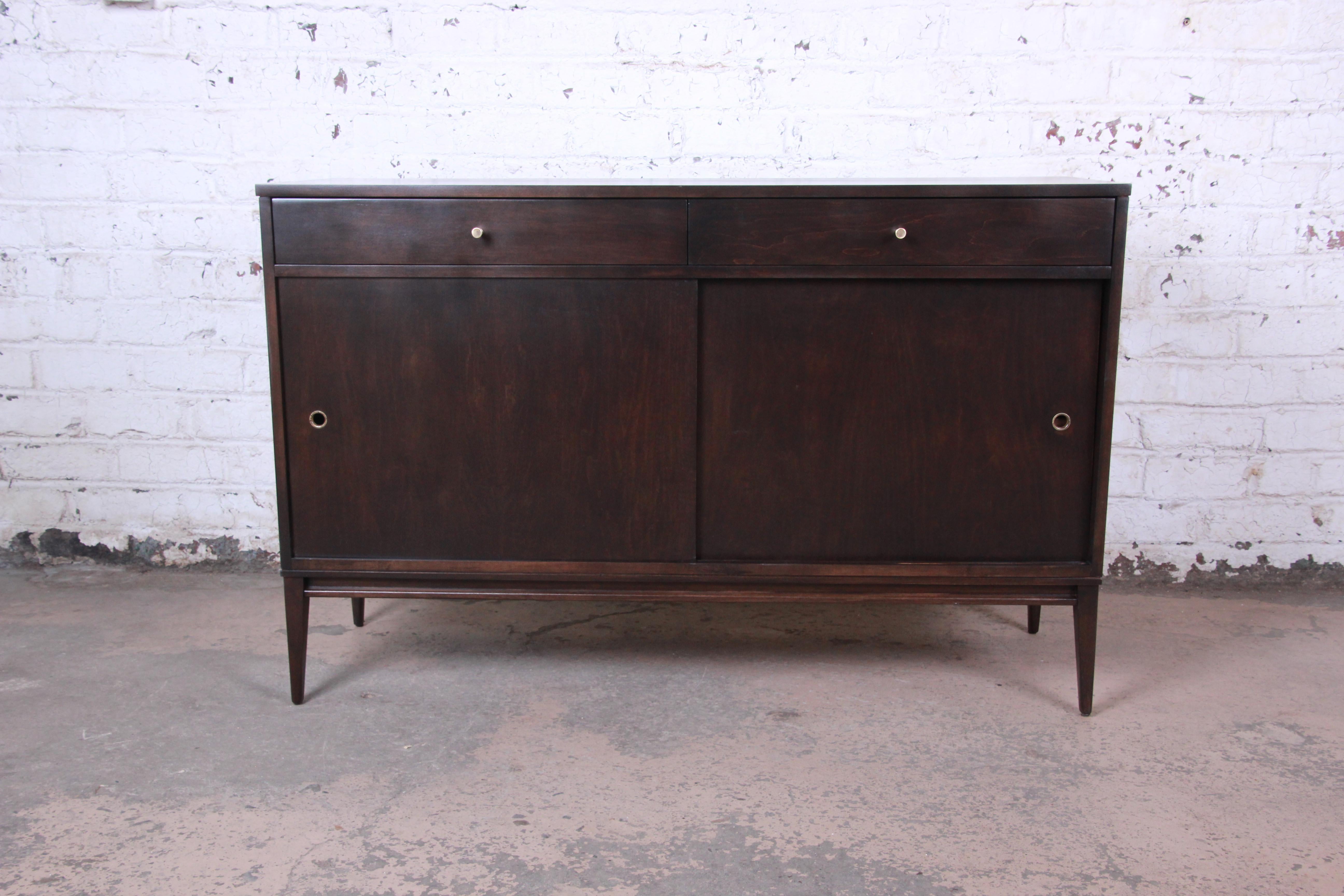 Offering an exceptional Mid-Century Modern sideboard credenza designed by Paul McCobb for his Planner Group line for Winchendon Furniture. The credenza features solid maple construction with stunning wood grain, newly restored in an onyx finish. It