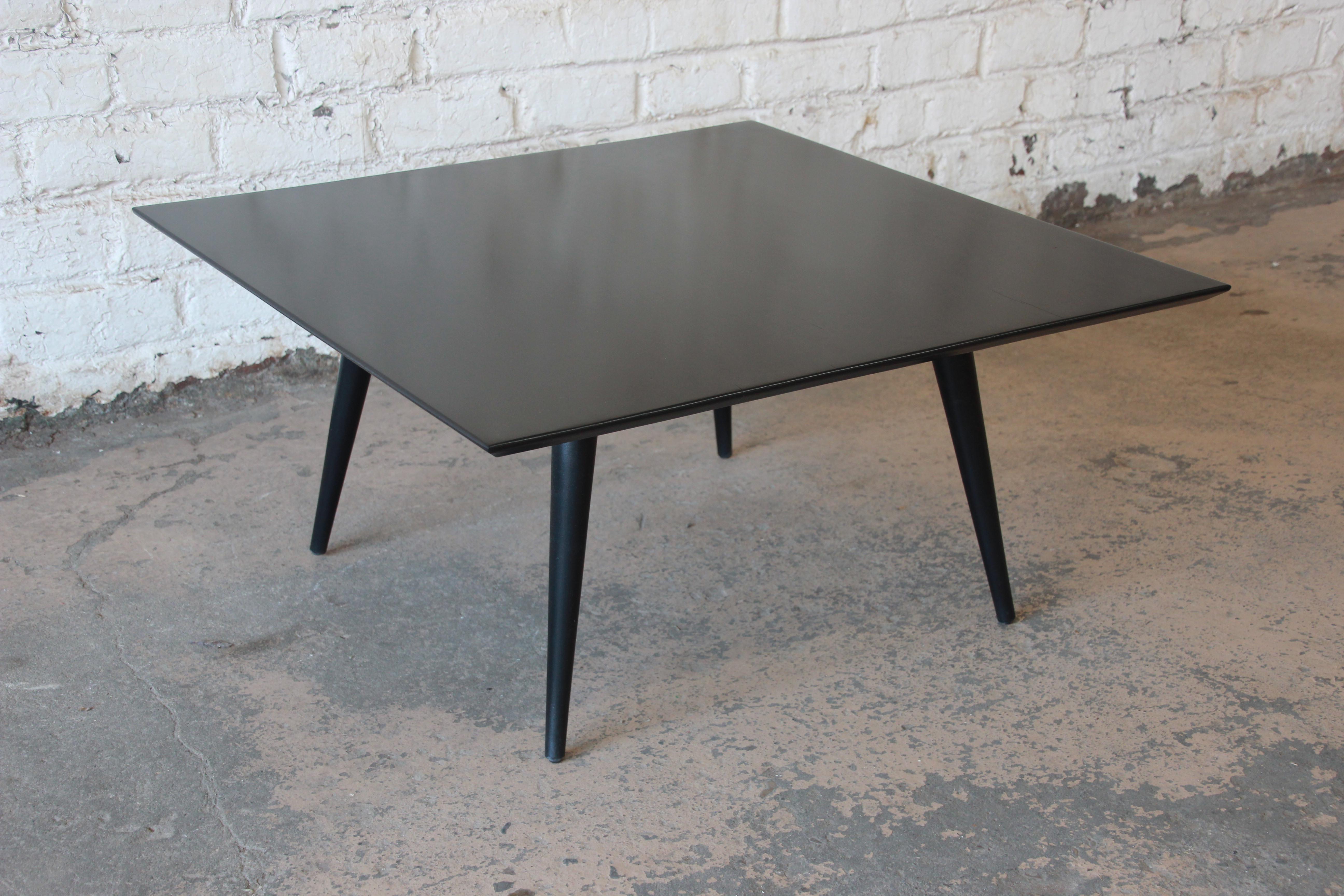 Offering a sleek and stylish Mid-Century Modern coffee table designed by Paul McCobb for his Planner Group line for Winchendon Furniture. The table features solid birch construction with a black lacquered finish and nice tall tapered legs. The table