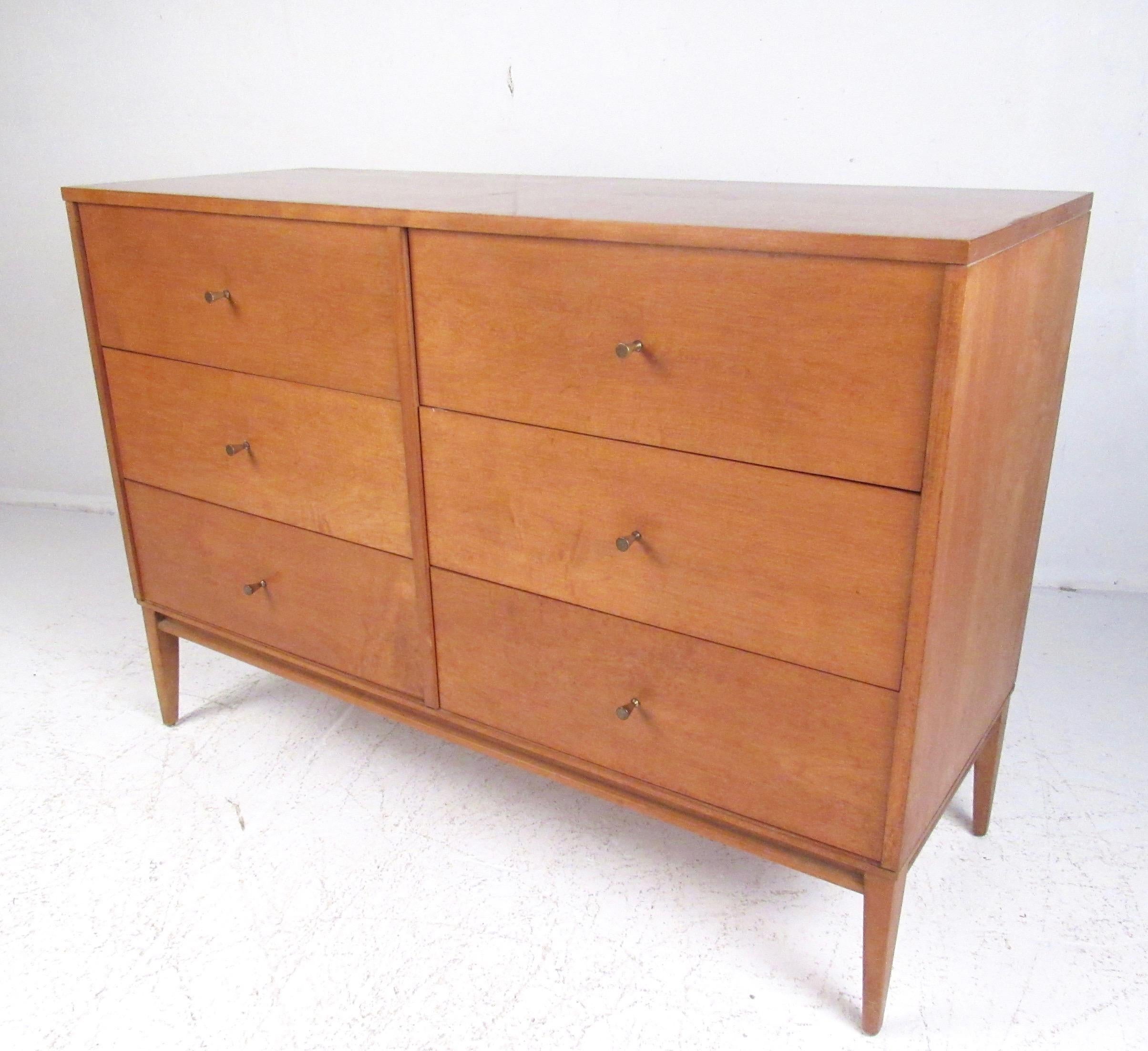 Vintage modern six-drawer bedroom dresser by Paul McCobb features spacious dovetailed drawers, iconic metal drawer pulls, tapered legs, and stylish midcentury maple finish. This Planner Group dresser combines spacious storage in a compact design,