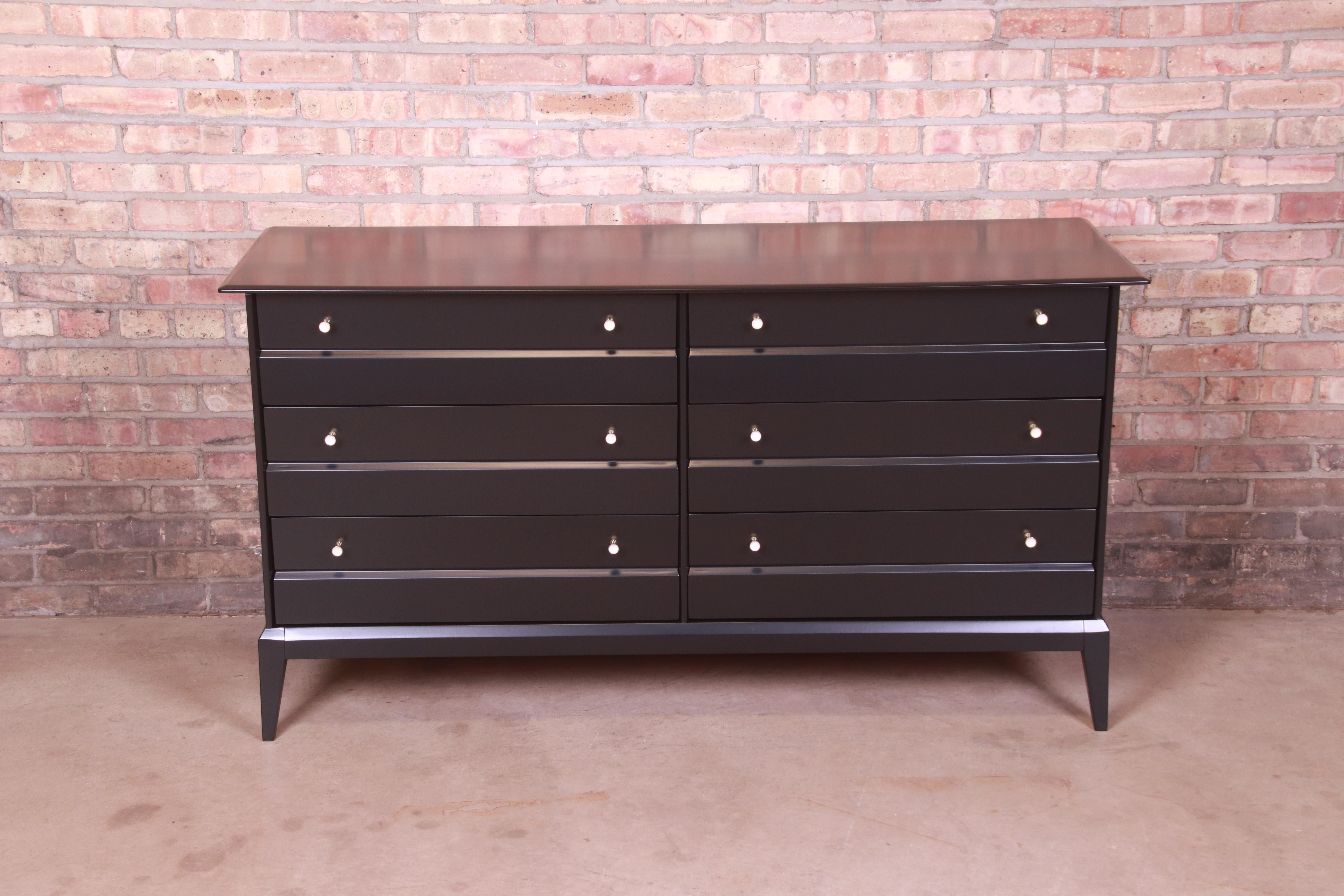 A sleek and stylish black lacquered mid-century modern dresser or credenza

In the style of Paul McCobb's iconic 
