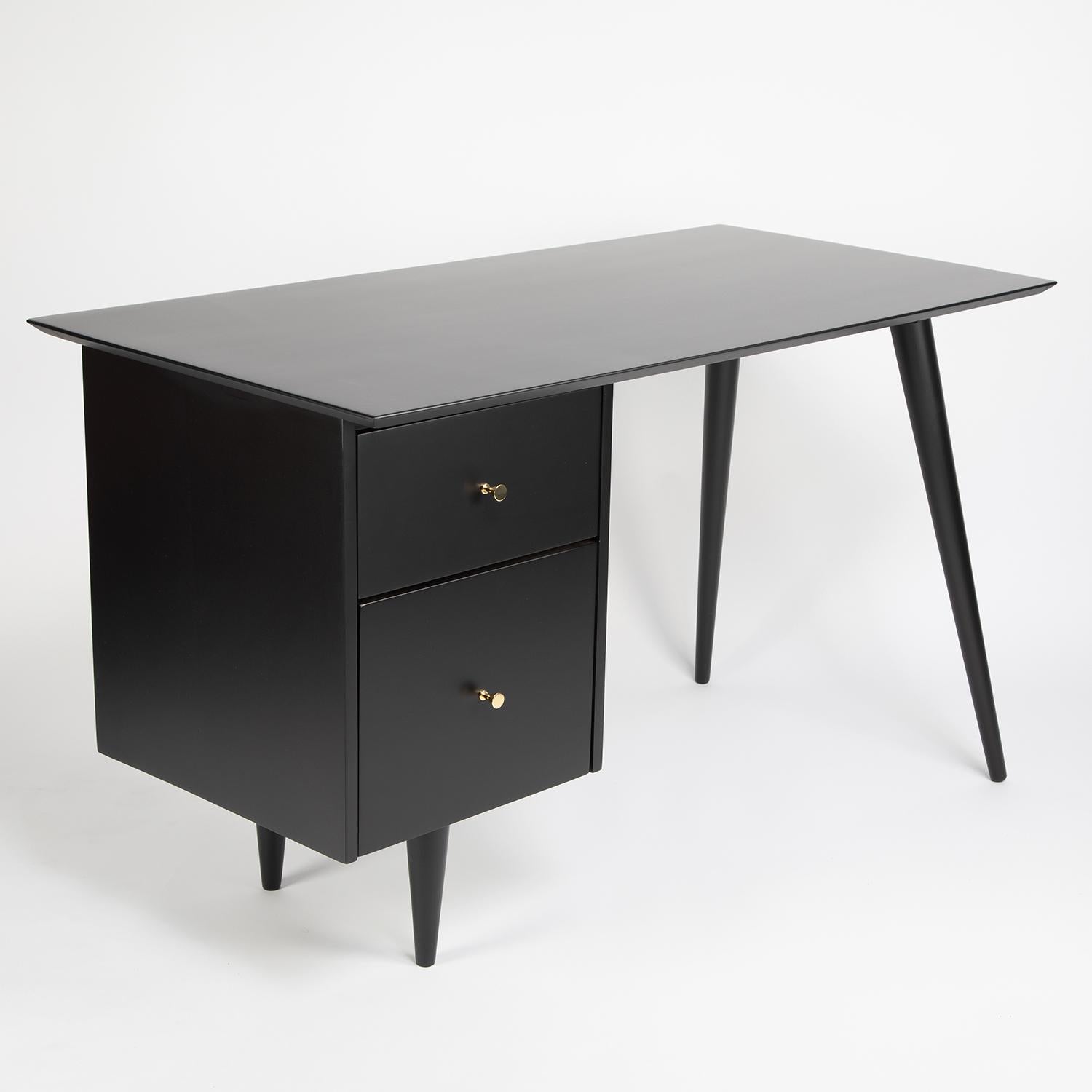 Stylish desk in ebonized maple with tapering legs and brass pulls by Paul McCobb, for the Planner Group collection for Winchendon Furniture, circa 1950s (signed).