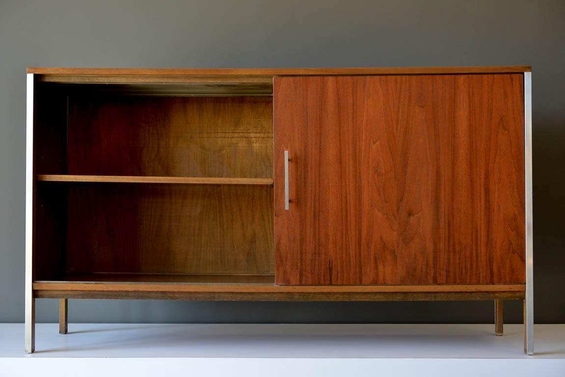 Paul McCobb walnut cabinet or room divider, circa 1965. Walnut with brushed aluminium trim and original hardware. Dual front and back sliding doors allow easy access to items inside. Great for a media cabinet. Seen in our Modern Vault Showroom at