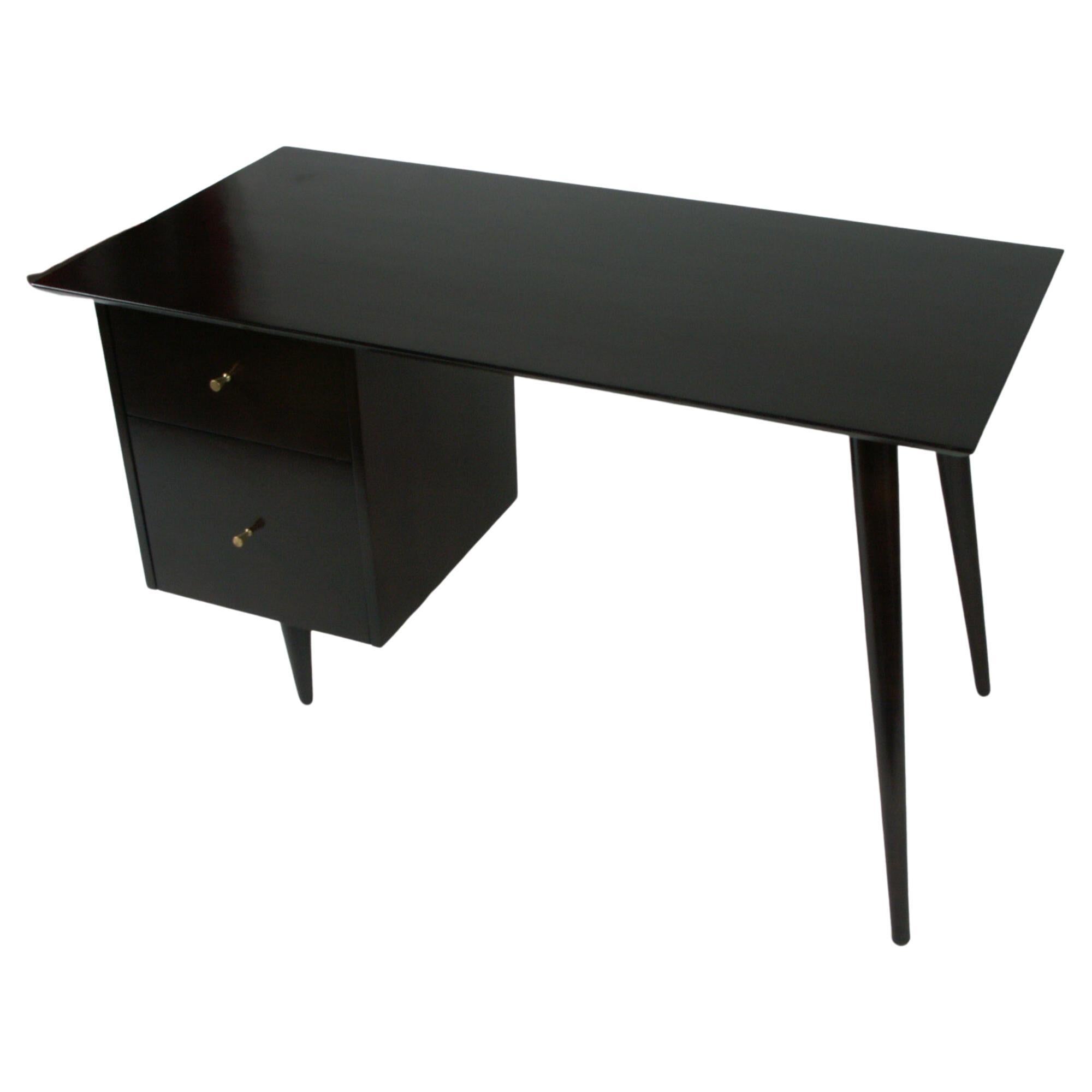 Paul McCobb Planner Group desk shown in dark espresso stain, with bank of drawers with polished tapered brass pulls on left side and two tapered angular dowel legs on the right, To be refinished in dark espresso finish, the desk shown is sold, so