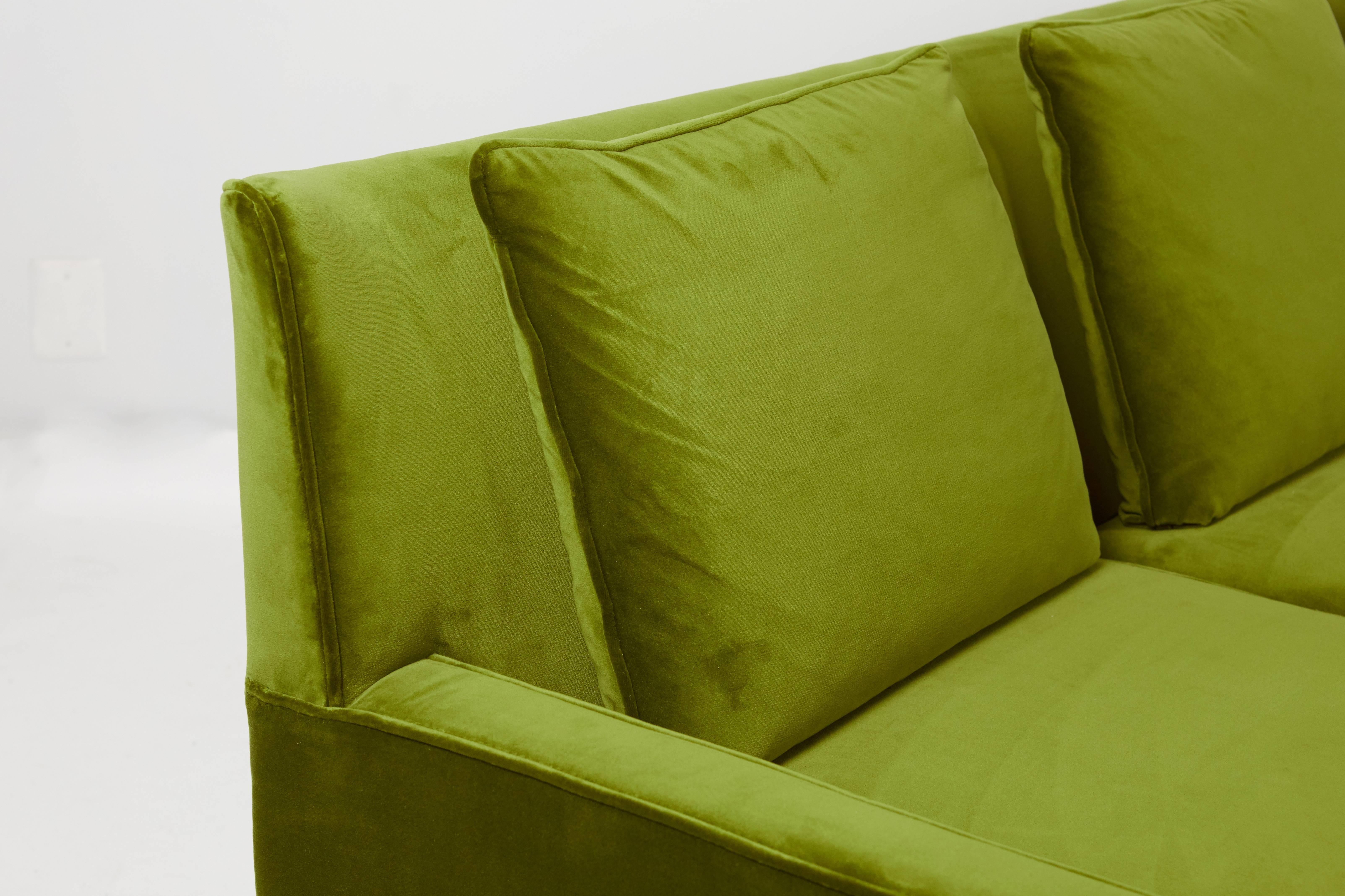 Paul McCobb wingback sofa, model 1307 for Directional furniture Fully restored walnut frame, finished in a dark walnut tone. Reupholstered in plush green velvet upholstery, with new down and foam. 

We have a pair of these sofas available. Priced