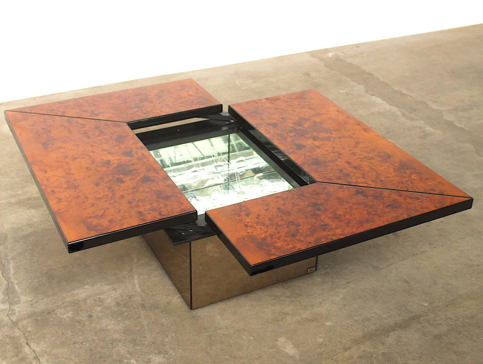 Stunning high gloss signed coffee table in lacquered burl wood by French designer Paul Michel. The table slides open to reveal a fully mirrored dry bar with storage for four liquor bottles and a glass shelf for glasses. The outside of the base is