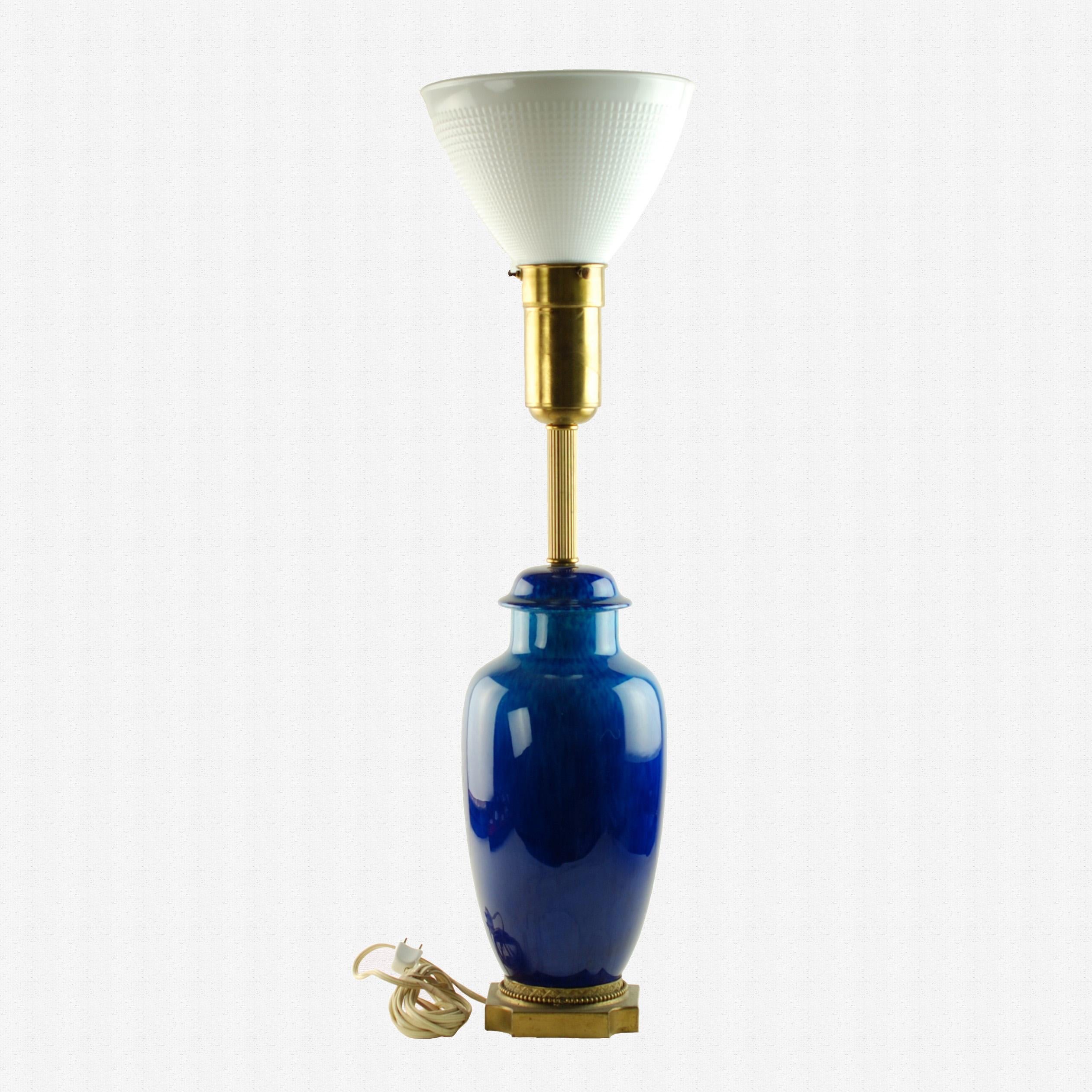 This Art Deco era porcelain torchiere table lamp was designed by Paul Milet (1870-1950) for Sèvres and comes complete with its original glass diffuser shade. The body of the lamp has been finished in a rich azure/sapphire jewel-toned glaze and is