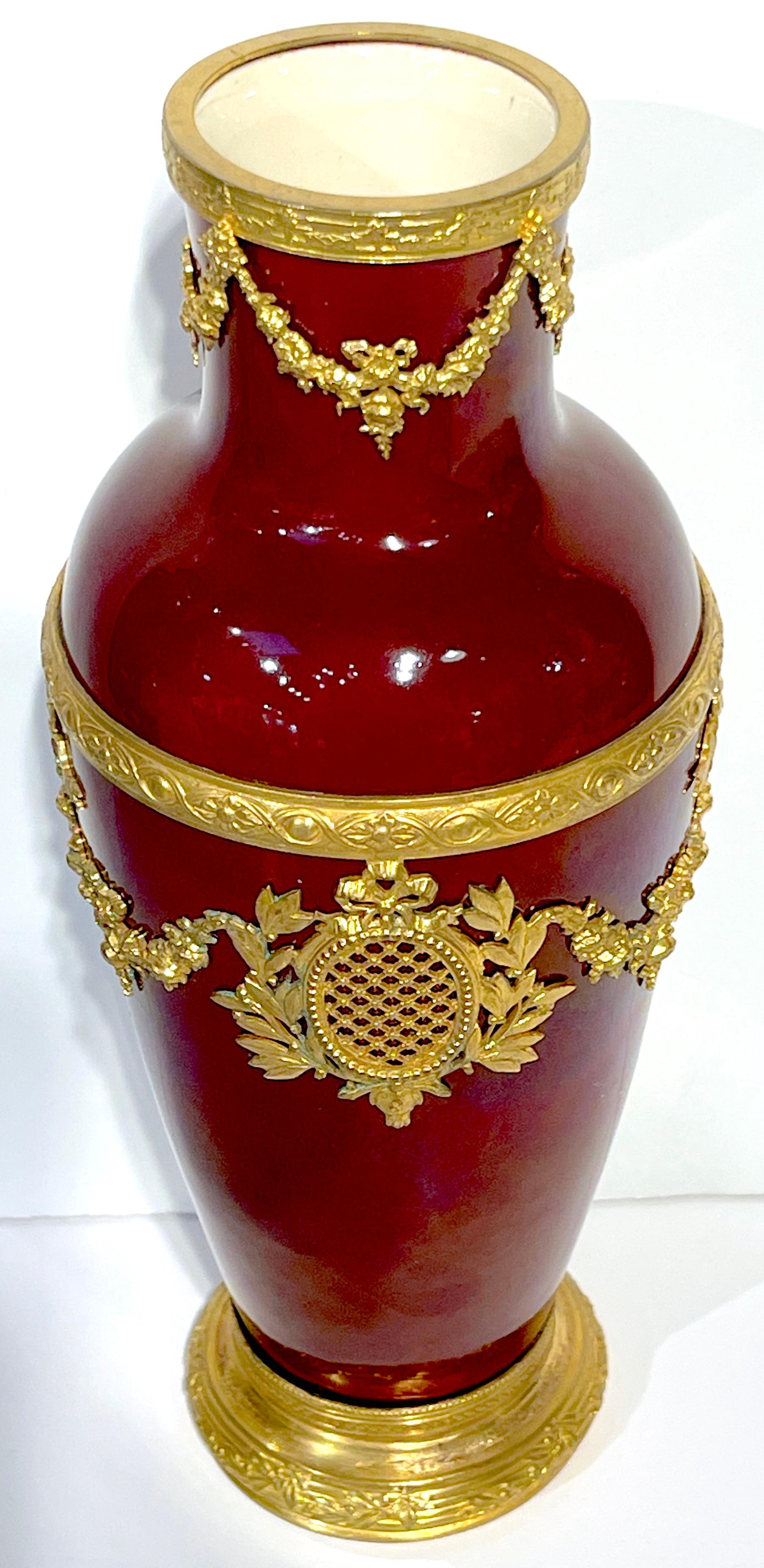 Paul Milet for Sevres Red Flambe Ormolu Mounted Neoclassical Vase 
Designed by Paul Milet (1870-1950)
Executed by Sevres Porcelain 

A beautiful Paul Milet for Sevres red flambe ormolu mounted neoclassical vase, a testament to timeless elegance.