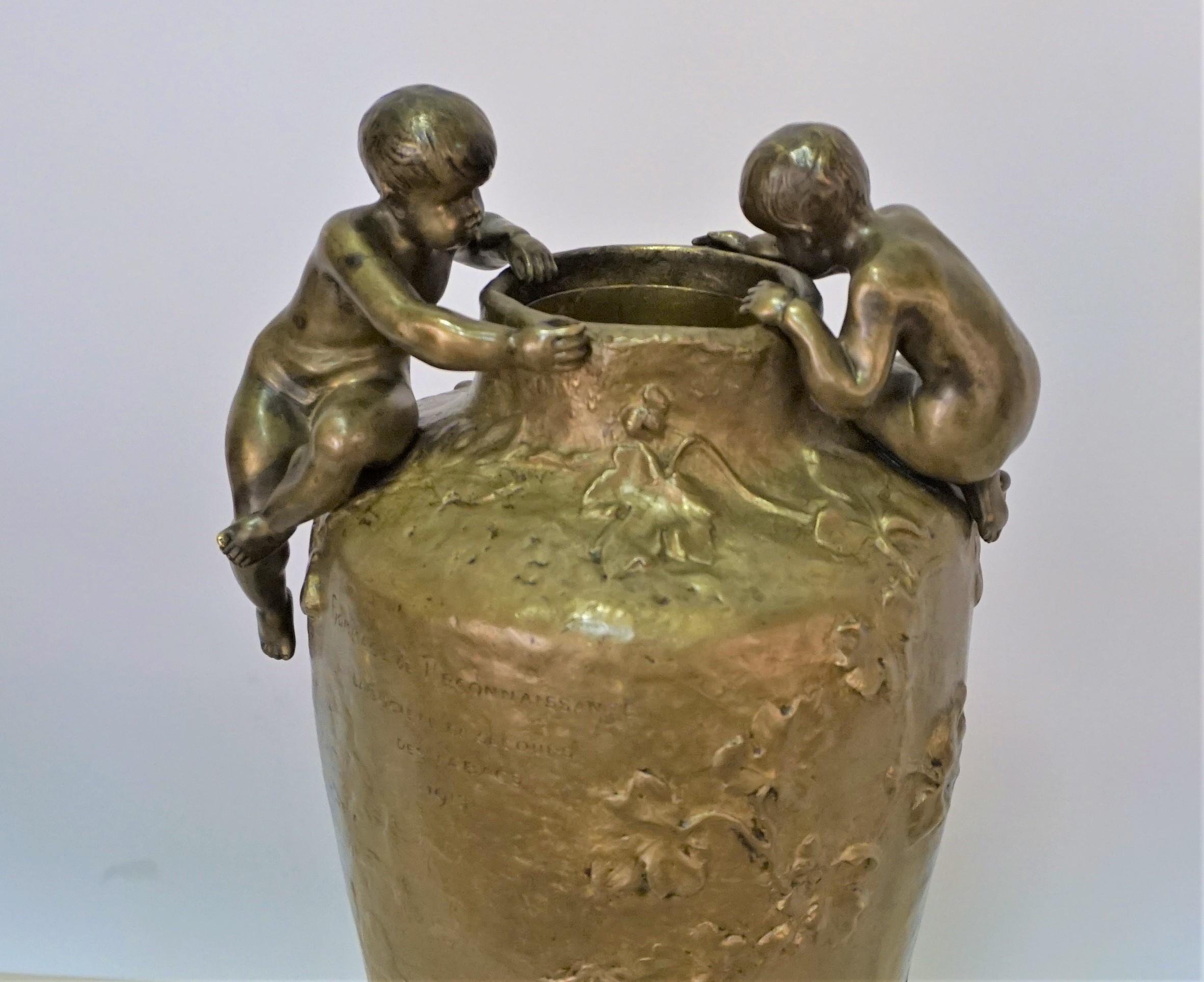 Bronzeguss mit einem jungen weiblichen Kobold und einem Putto, der auf einen belaubten Baum klettert, sowie zwei figuralen Puttengriffen.
Präsentationsstück.


 