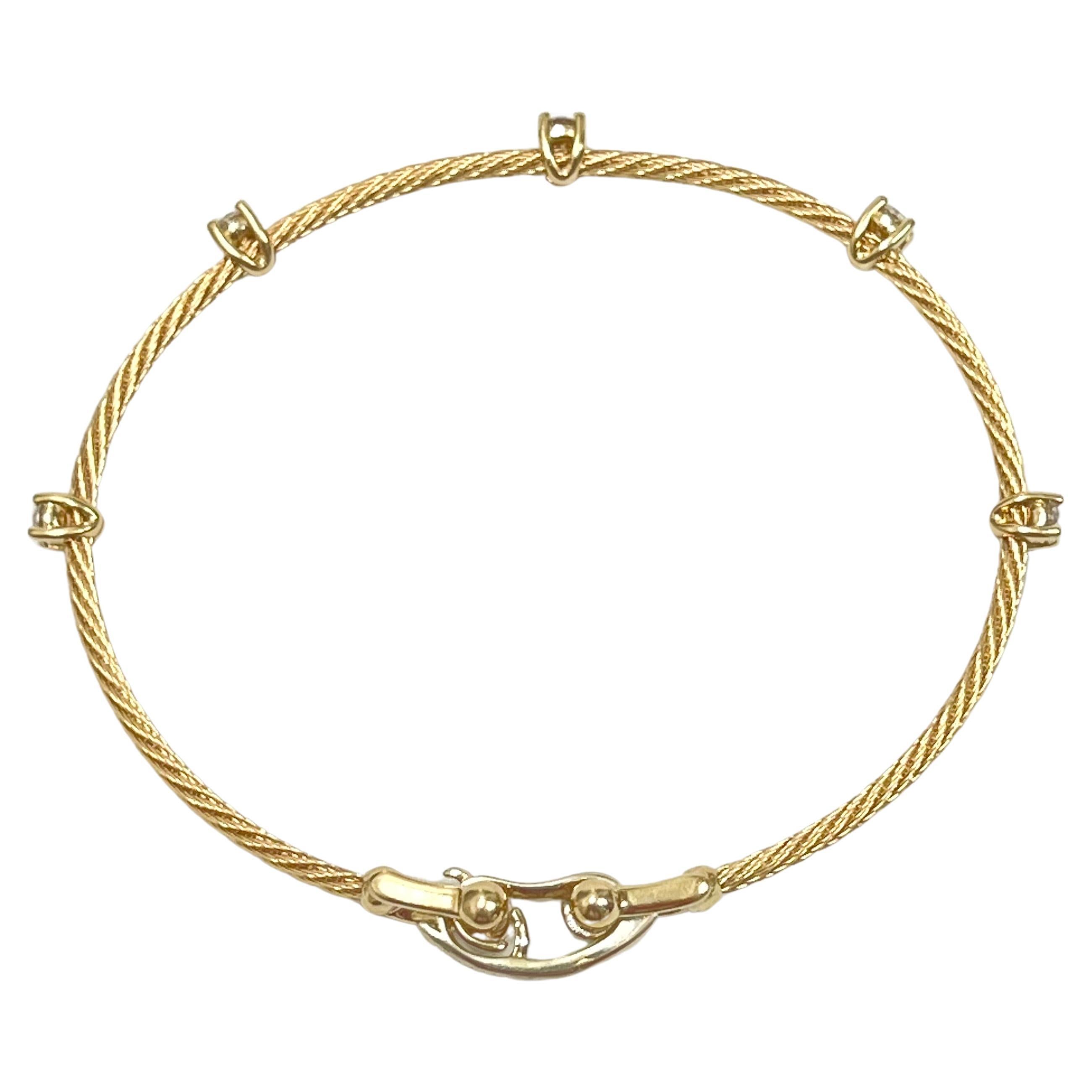 Larger version of the Paul Morelli 18k yellow gold single-strand wire cable bracelet.  The spiraled cable strands are accented by five round brilliant-cut diamonds weighing 0.50 total carats.  Fold-over clasp signed 'Morelli © 750'.  Measuring