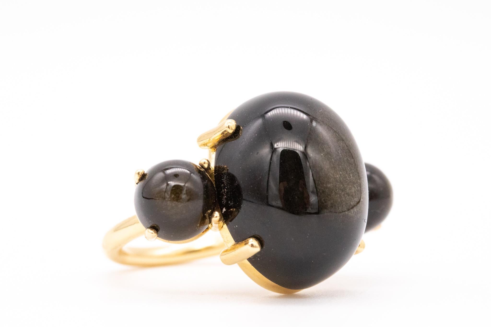 Cocktail ring designed by Paul Morelli.

A modern three-gemstones setting, crafted in solid 18 karats of high polished yellow gold. Mounted with three cabochons cuts of natural black-greyish obsidian, with a combined weight of 26 carats.

Have a