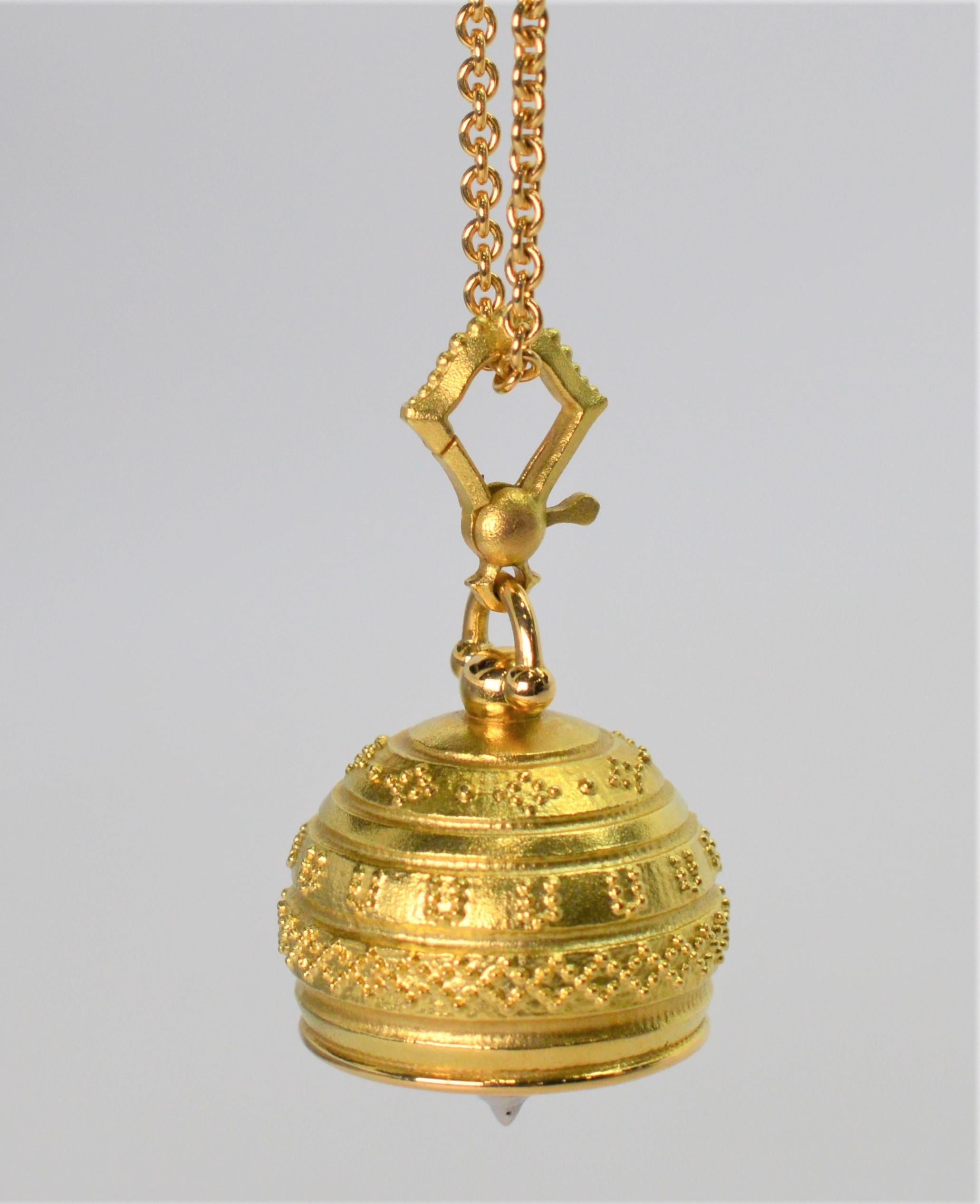 A soft, whimsical tone reverberates from this meditation bell charm in eighteen karat yellow gold by Paul Morelli. 
The charm measures approximately 3/4 x 3/4 inch and is outfitted with an enhancer clip.  
Suspended on a lengthy thirty inch eighteen