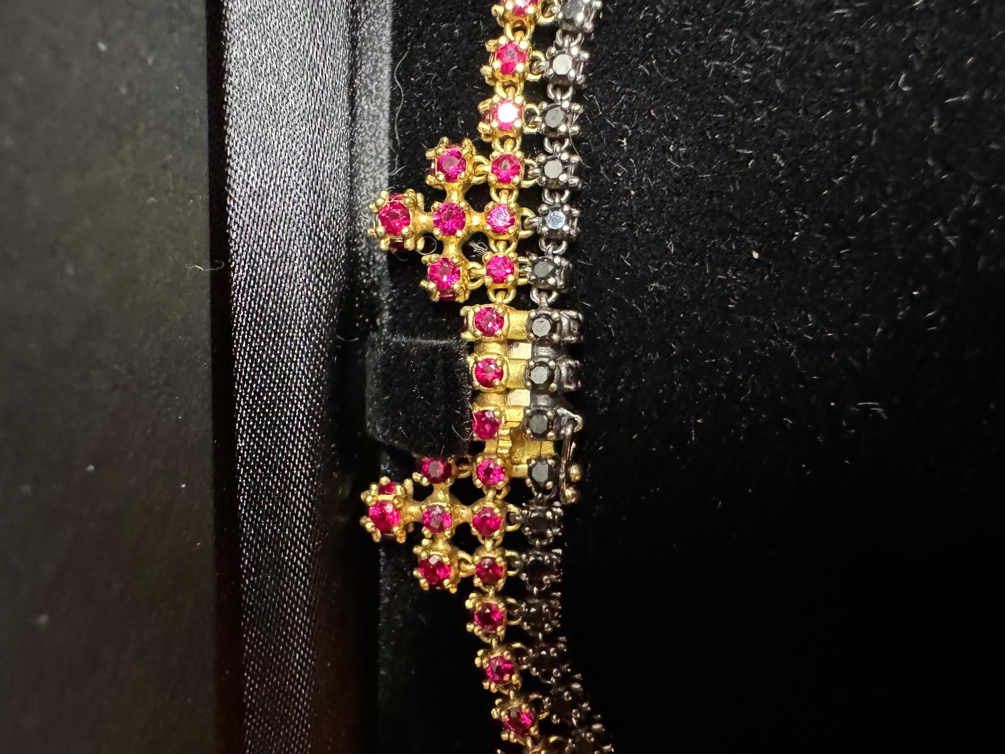 This is a one-of-a-kind Paul Morelli necklace containing 118 black diamonds and 193 rubies. It is set in 18 Karat Yellow Gold and is 16 inches long. It elegantly hangs from the neckline and has a safety clasp. When I consulted with Paul Morelli, the