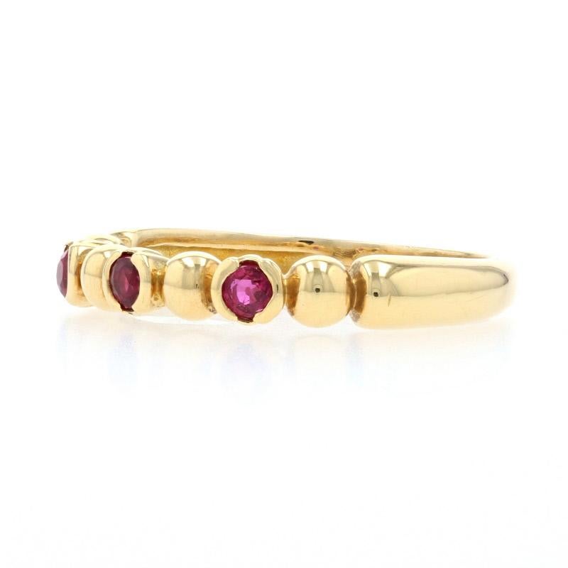 This Paul Morelli designer ring features a simple, yet, elegant design that is perfect for wearing alone or paired with other stackable bands!  Three round cut rubies are displayed along the face of the high karat band.  The .33 carat total weight