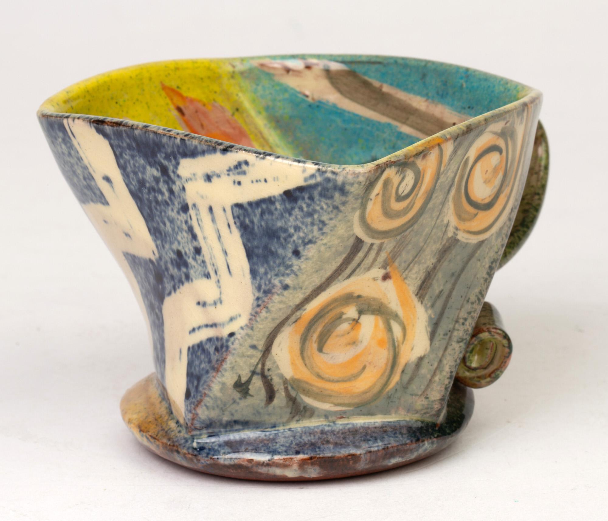 From an extensive collection of studio pottery we are pleased to offer this fine abstract form studio pottery mug by Cornish based potter Paul Northmore Jackson dated 1993. The mug of twisted square shape has a rounded base and flat strap handle