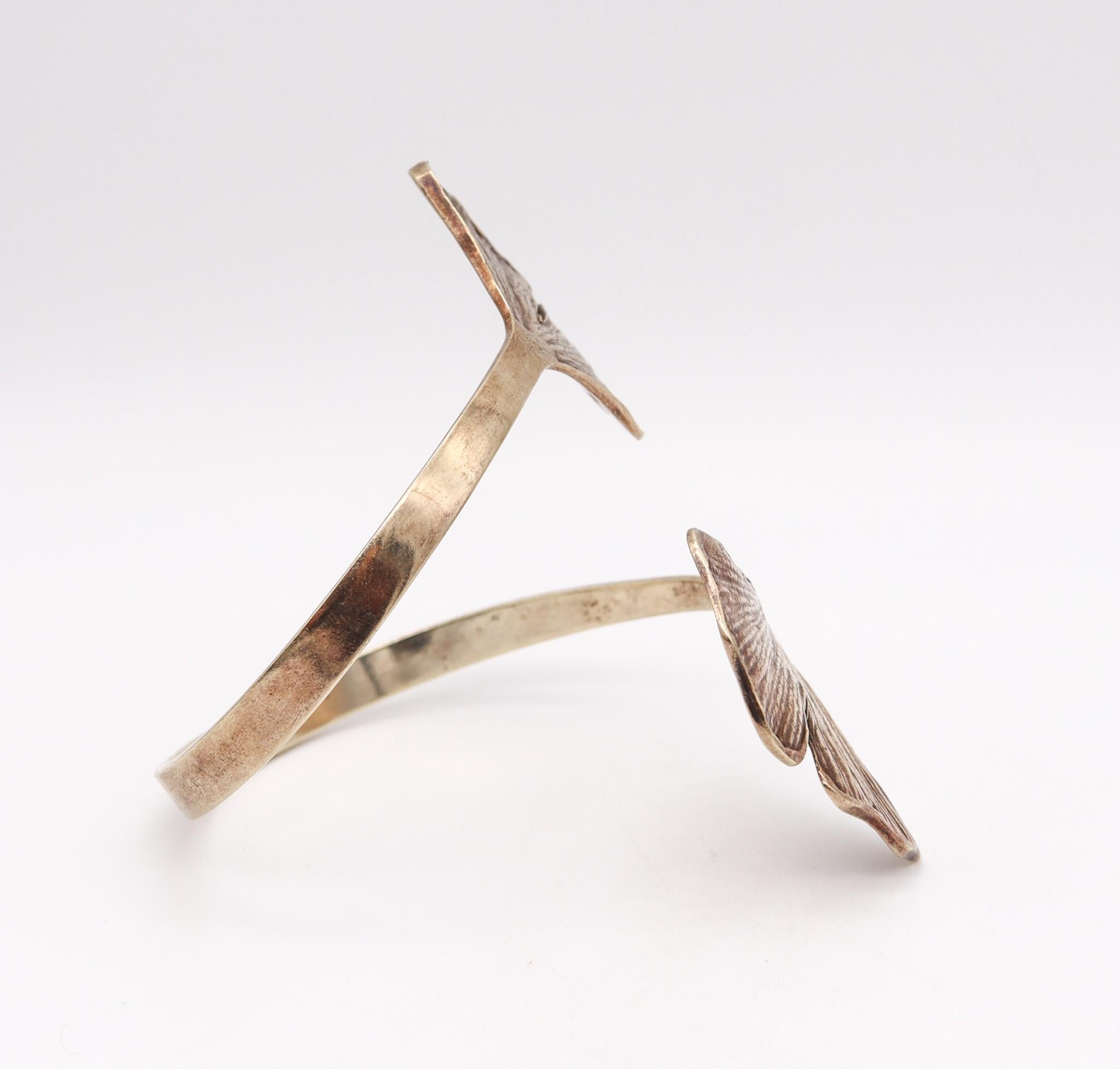 Double manchette en gingko conçue par Paul Oudet (1946-).

Un prototype de bracelet manchette sculptural, créé à Paris en France par le sculpteur Paul Oudet, dans les années 1970. Cette pièce organique a été réalisée comme une pièce unique en argent