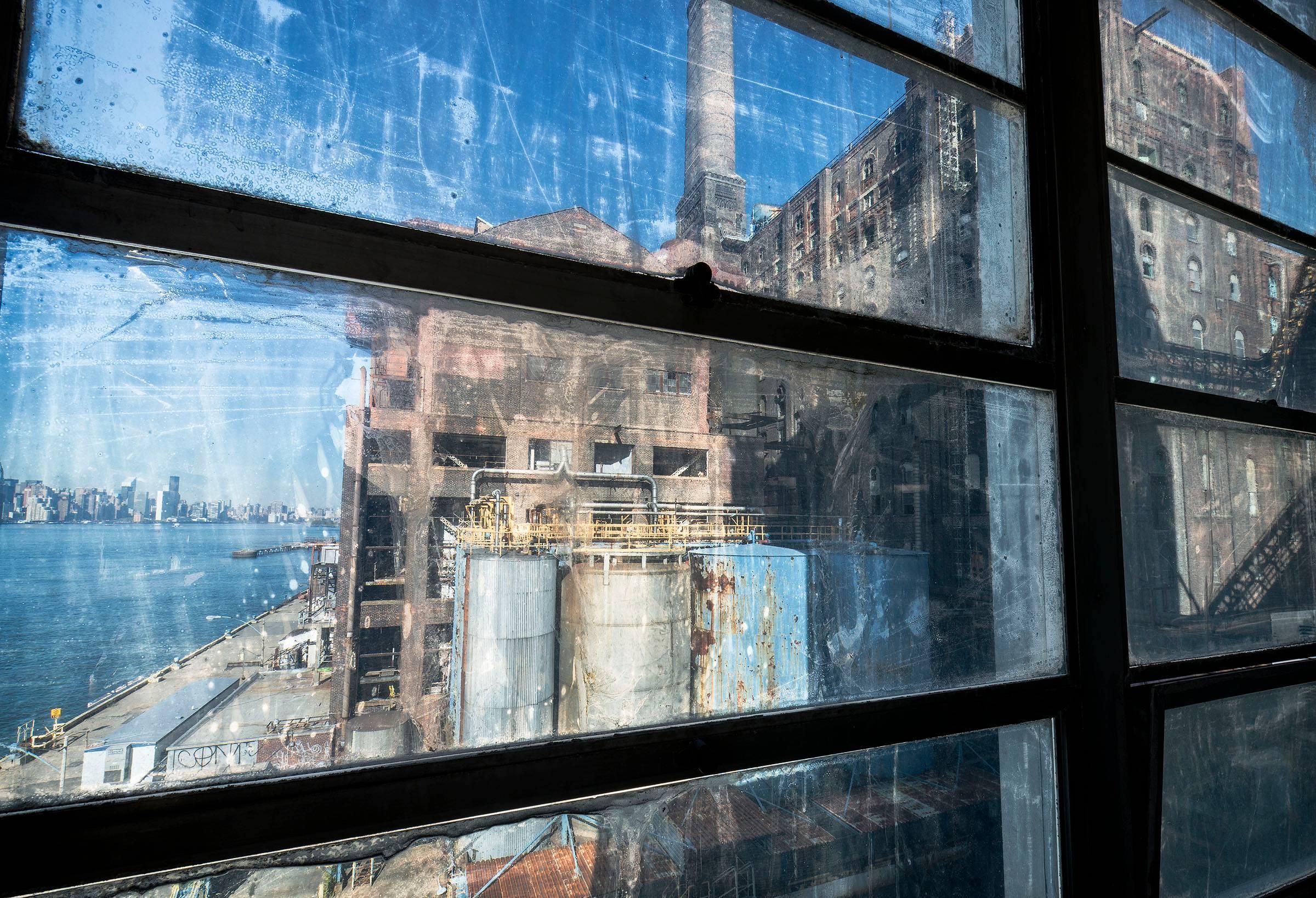 Paul Raphaelson Landscape Photograph - Through Window, 27"X40" photograph of Domino Sugar Refinery-  Brooklyn, New York