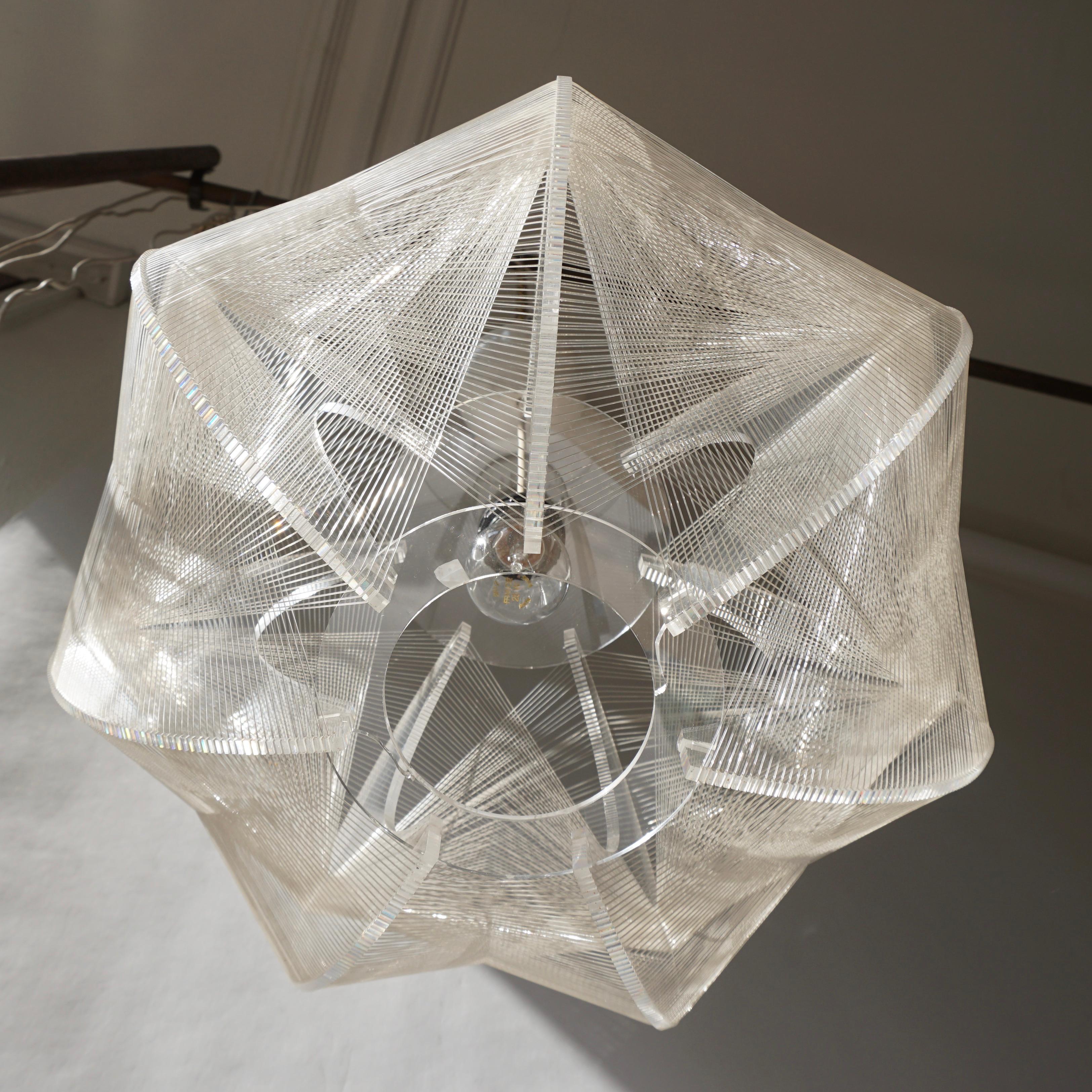 Clear wire pendant lamp by Paul Secon for Sompex, 1970s. Pendant lamp is made of clear Lucite with woven nylon strings surrounding the lightbulb, gives a warm light when lit.

Measures: Diameter 48 cm.
Height fixture 27 cm.
Total height 90 cm.