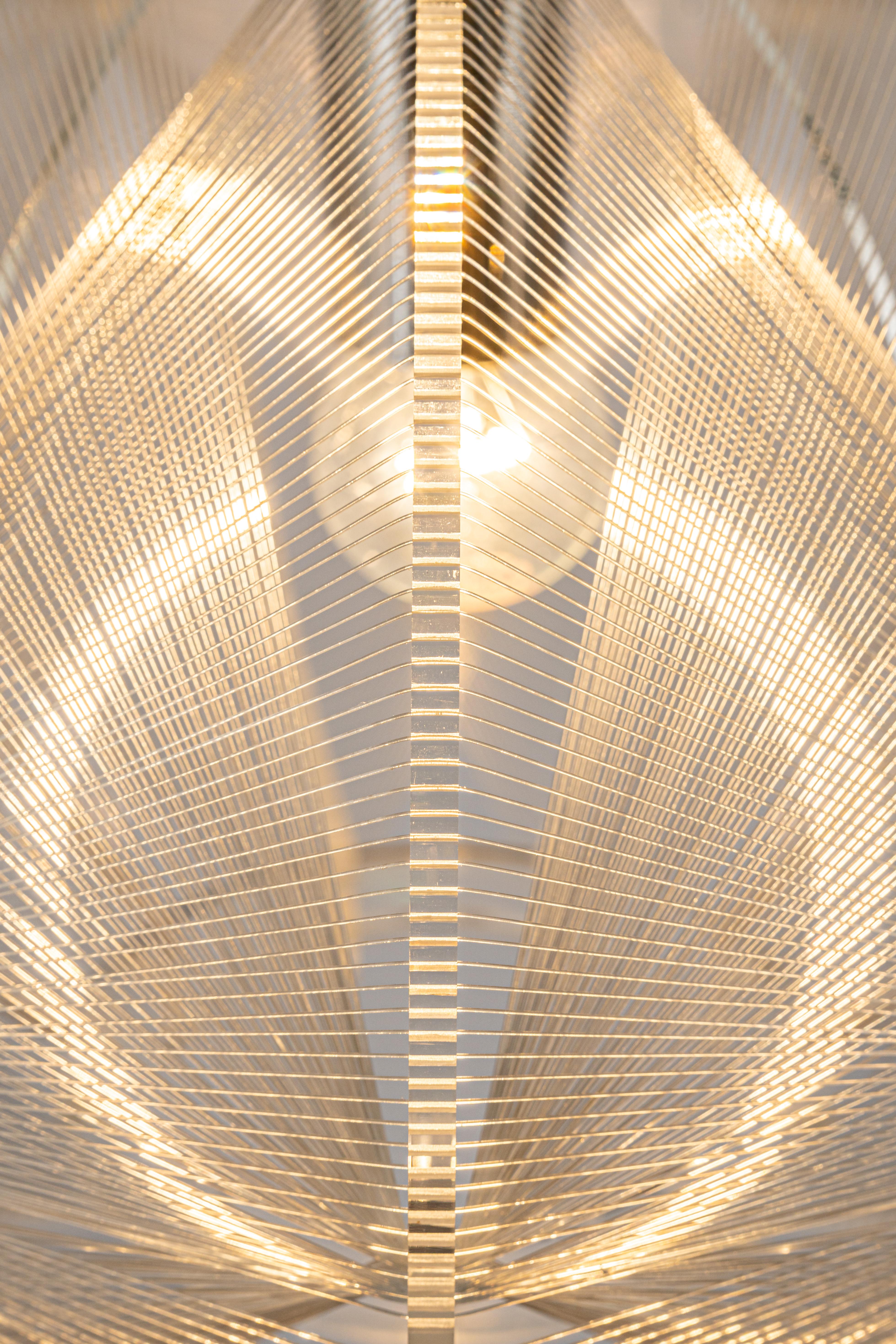 Lampe suspendue en fil métallique transparent par Paul Secon pour Sompex, années 1970. La lampe suspendue est fabriquée en Lucite clair avec des fils de nylon tissés entourant l'ampoule, ce qui donne une lumière chaude lorsqu'elle est